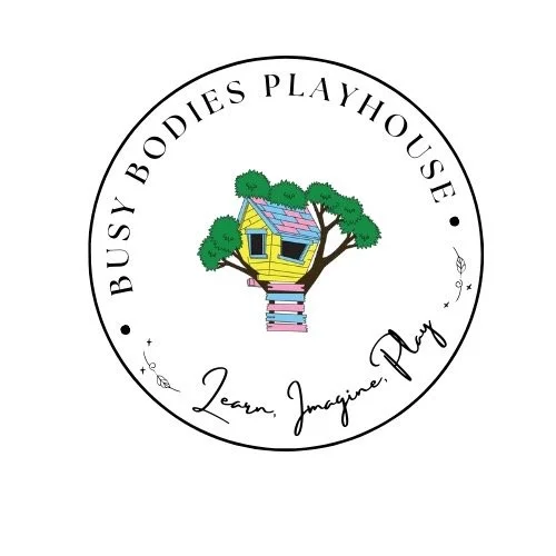 Logo with a yellow treehouse with pink stairs and green trees inside a circular border. Text reads 'Busy Bodies Playhouse' and 'Learn, Imagine, Play'.