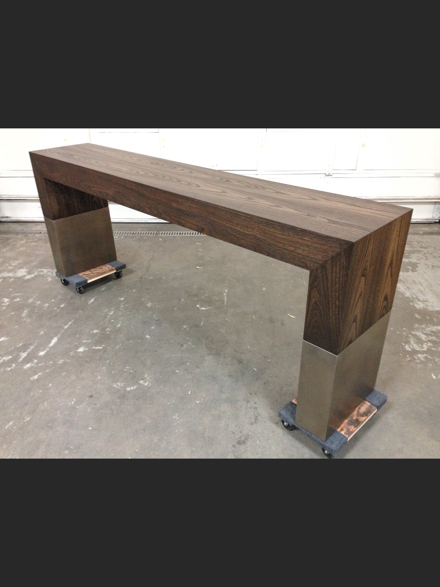 A long, modern wooden table with metal legs.