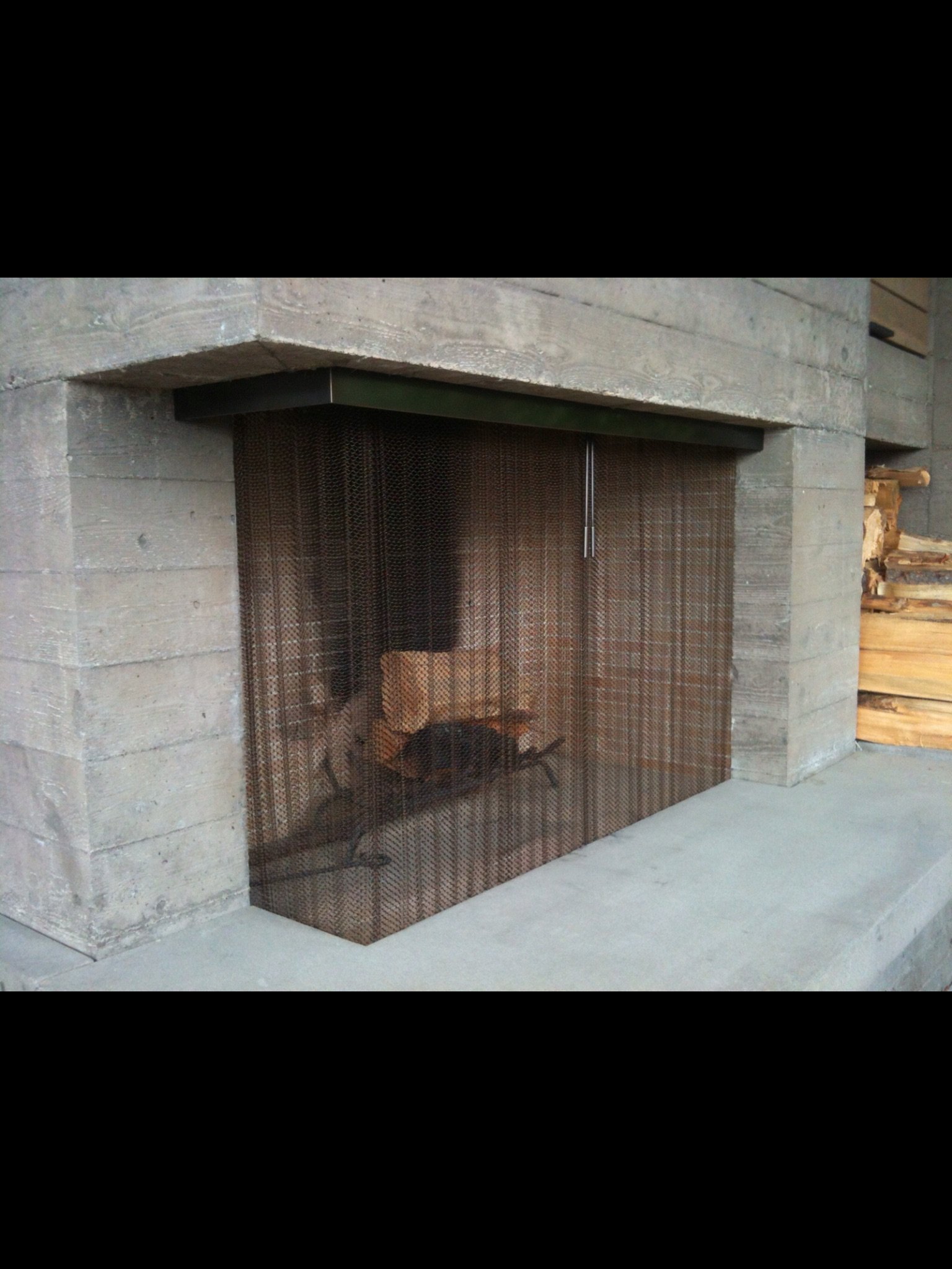 A fireplace with a metal mesh screen.
