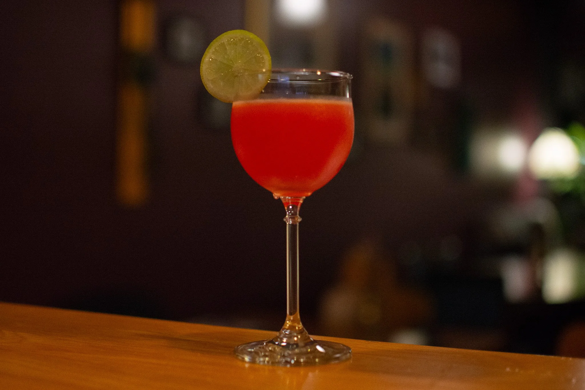 cocktail in nick and nora glass with lime garnish