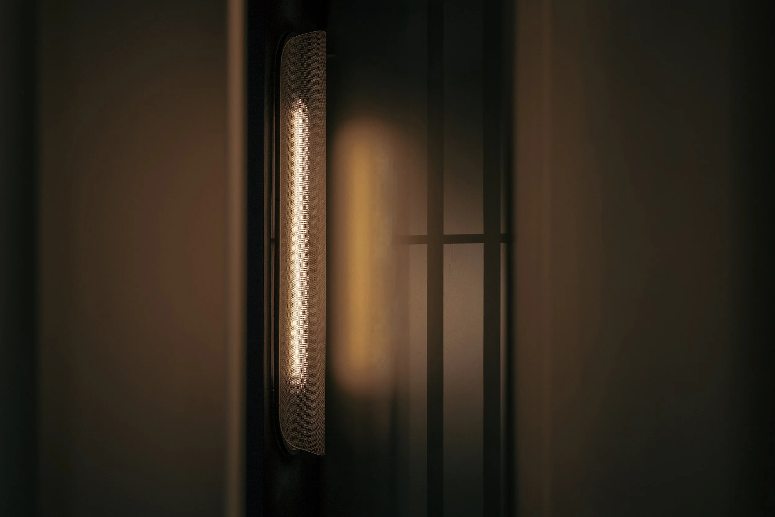 Moody detail of lighting, frosted glass, and screen silhouette