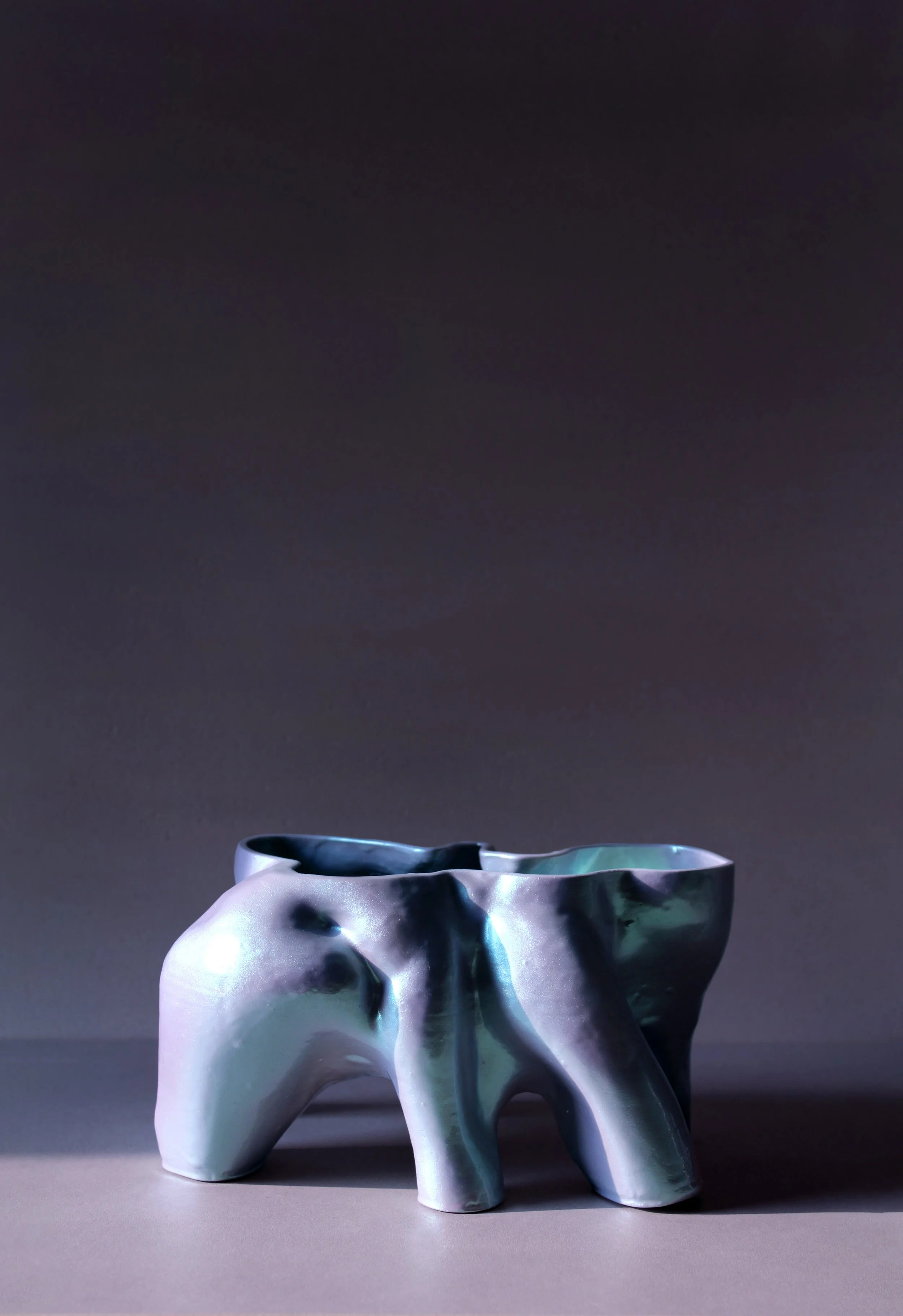 Quad-legged vessel with organic, folded contours and metallic glaze; part of Pet Objects 1’s sculptural domestic object exploration.