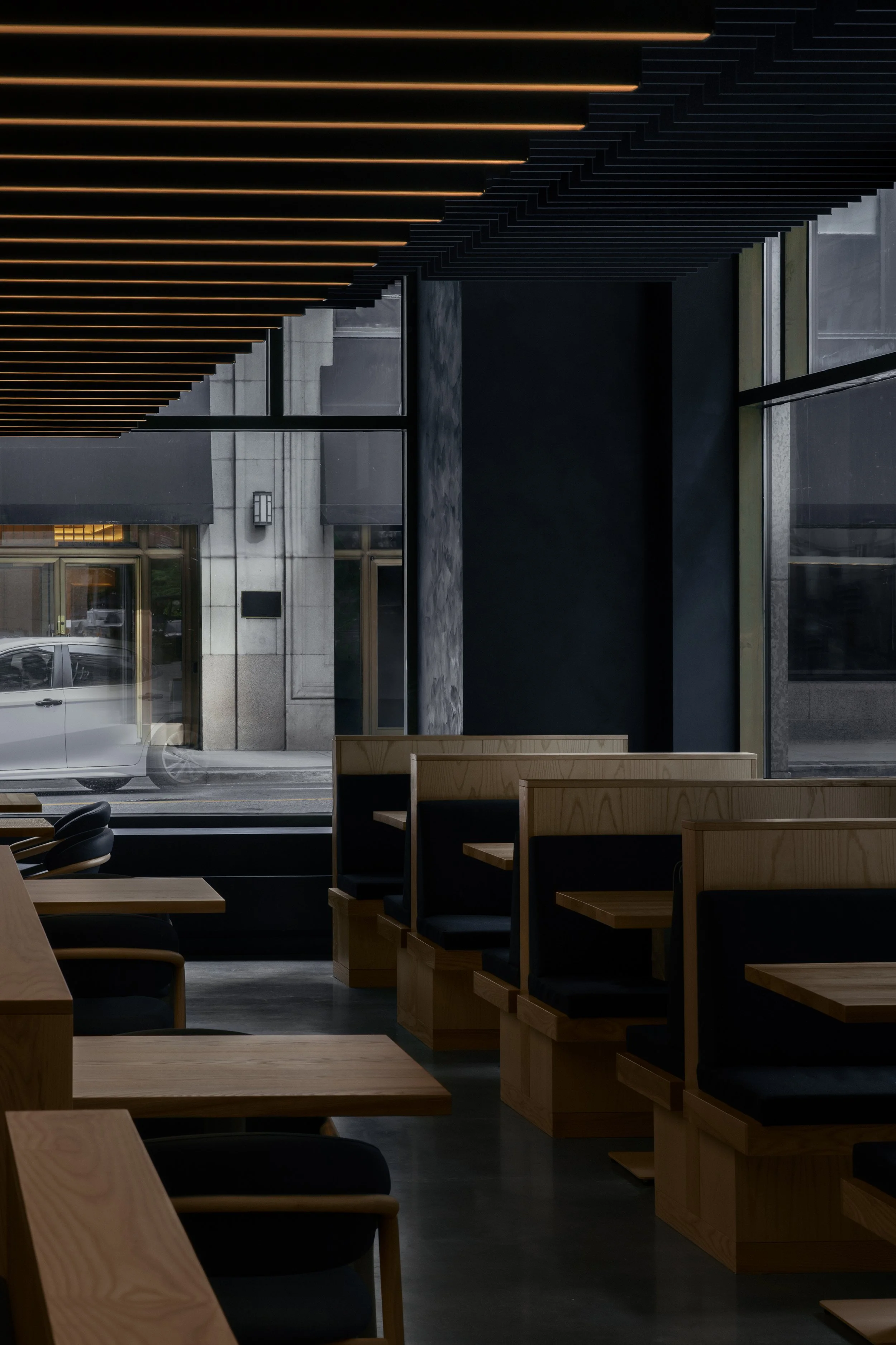 Japanese restaurant with acoustic panels on the ceiling and wood banquettes