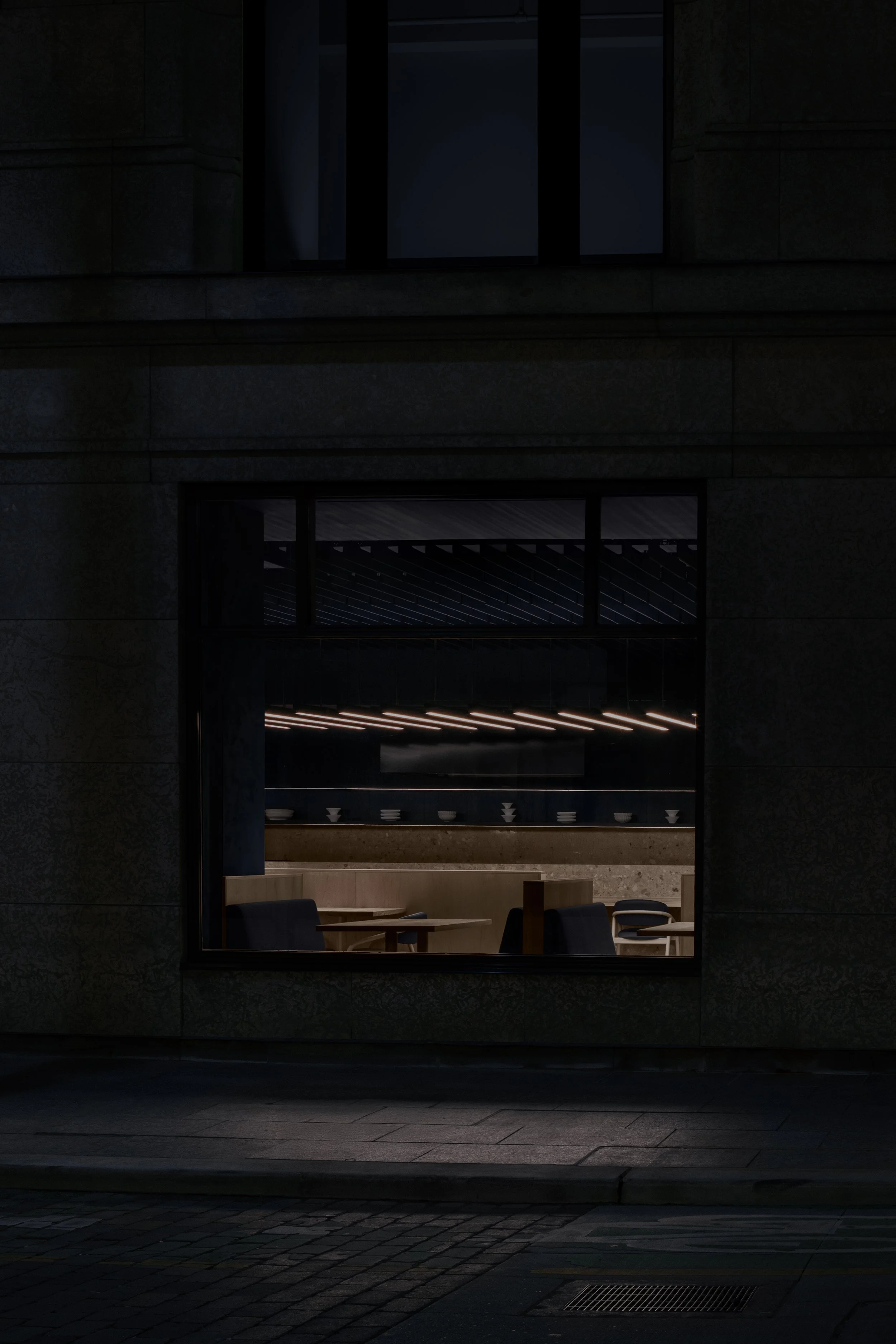 Shinji Japanese viewed from outside showing minimalist lights and muted material palette