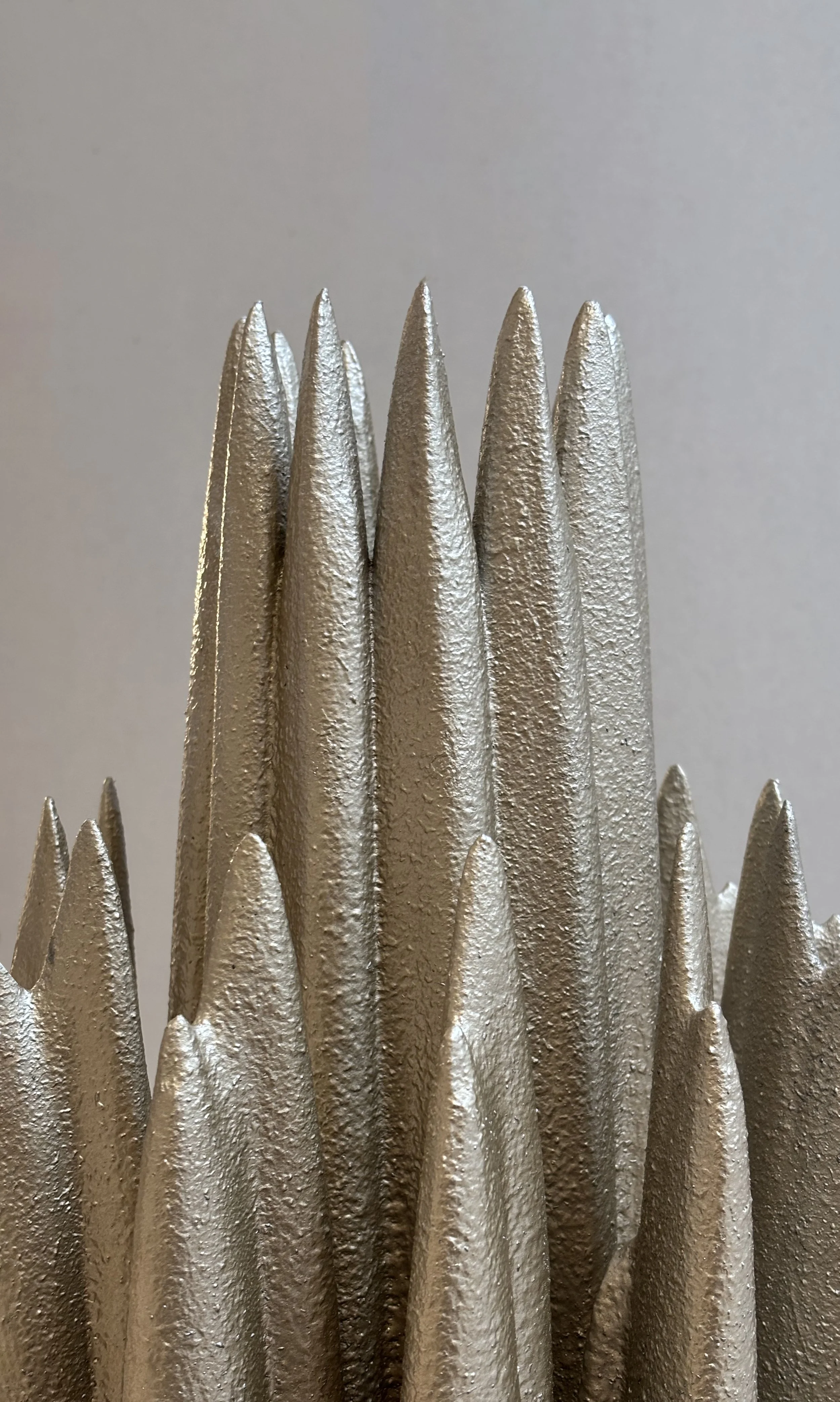 Detail image of floor lamp focusing on organic form and textured metallic finish