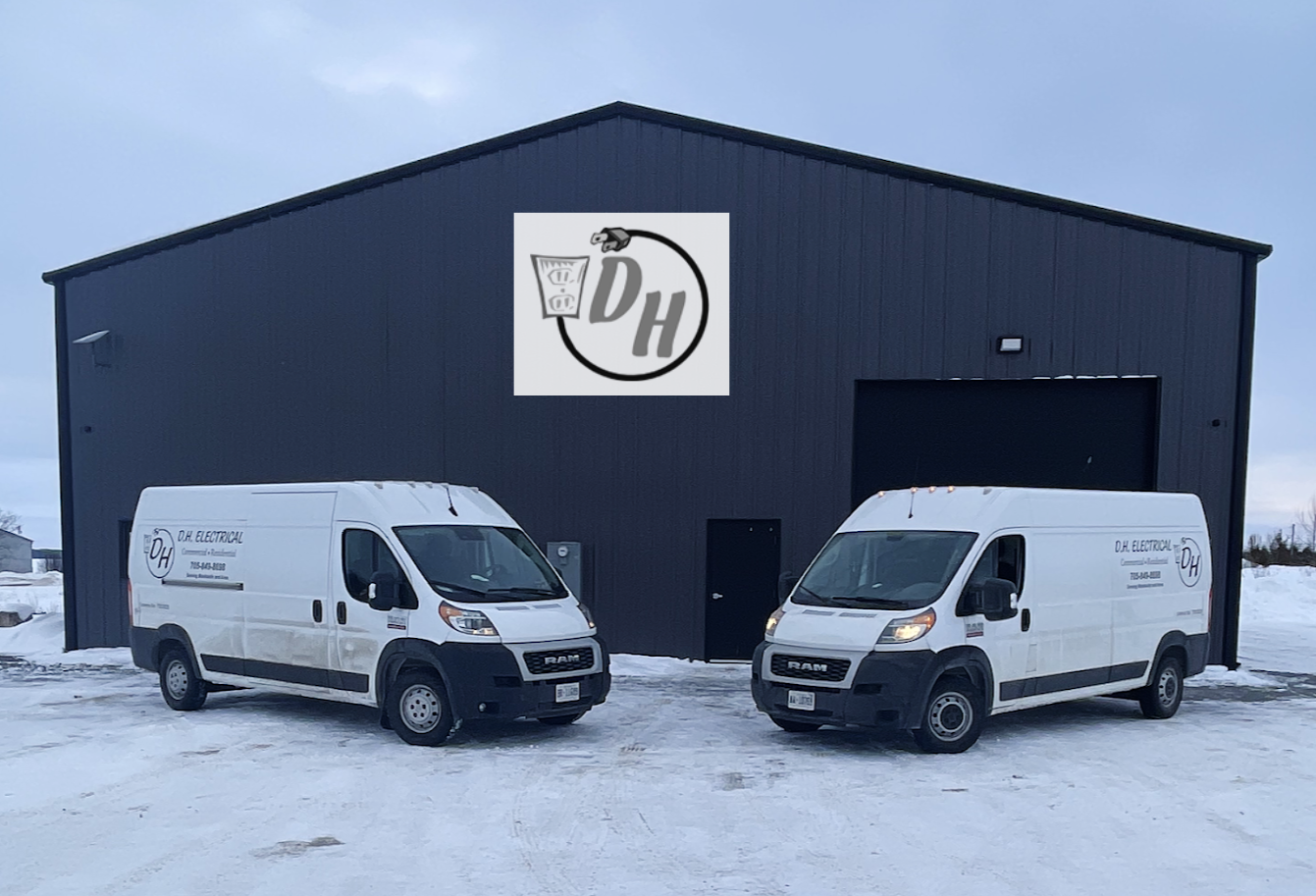 The DH Electrical shop with two white utility vans parked in front of it