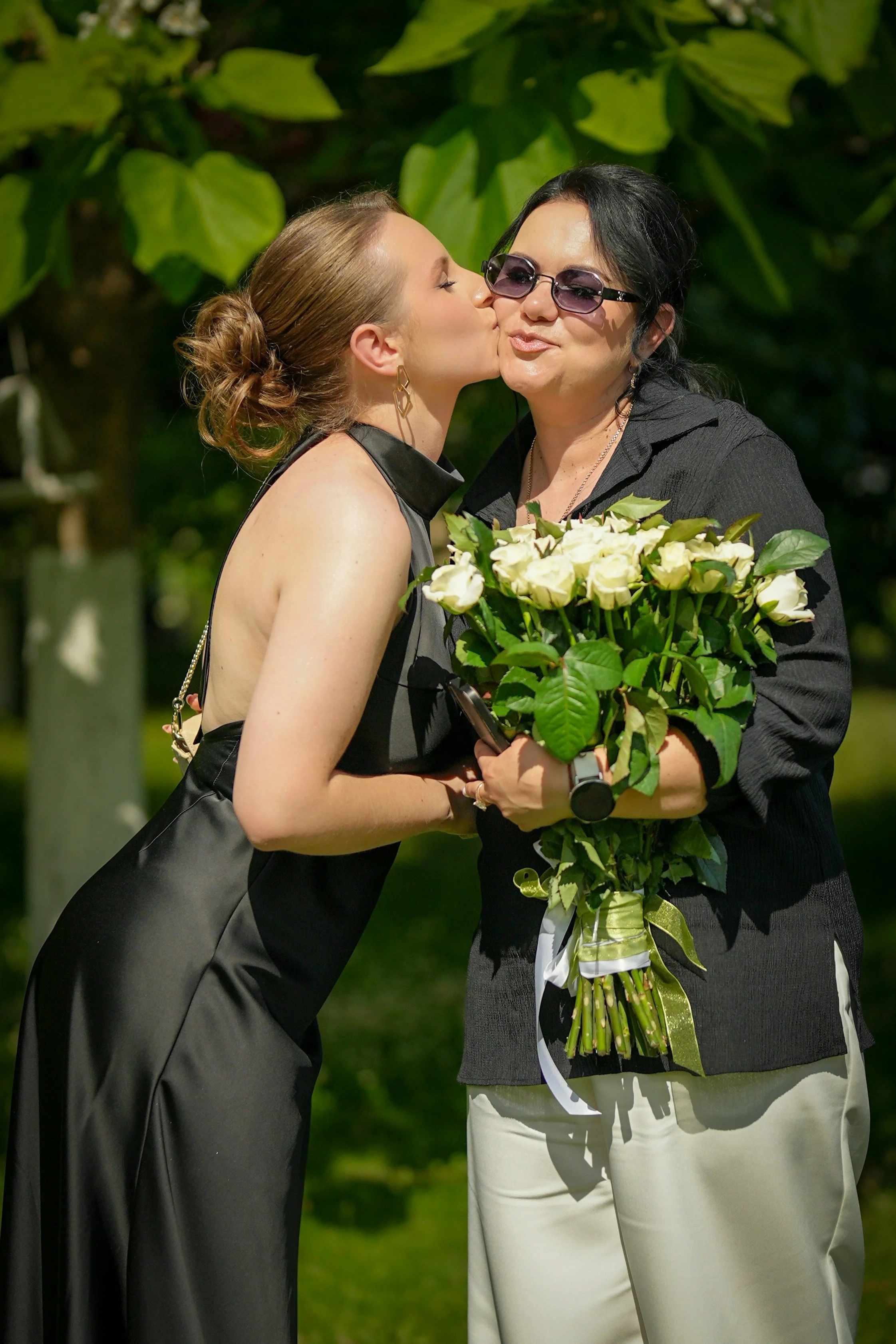 Utah wedding couple embracing by a lake, woman holding a bouquet