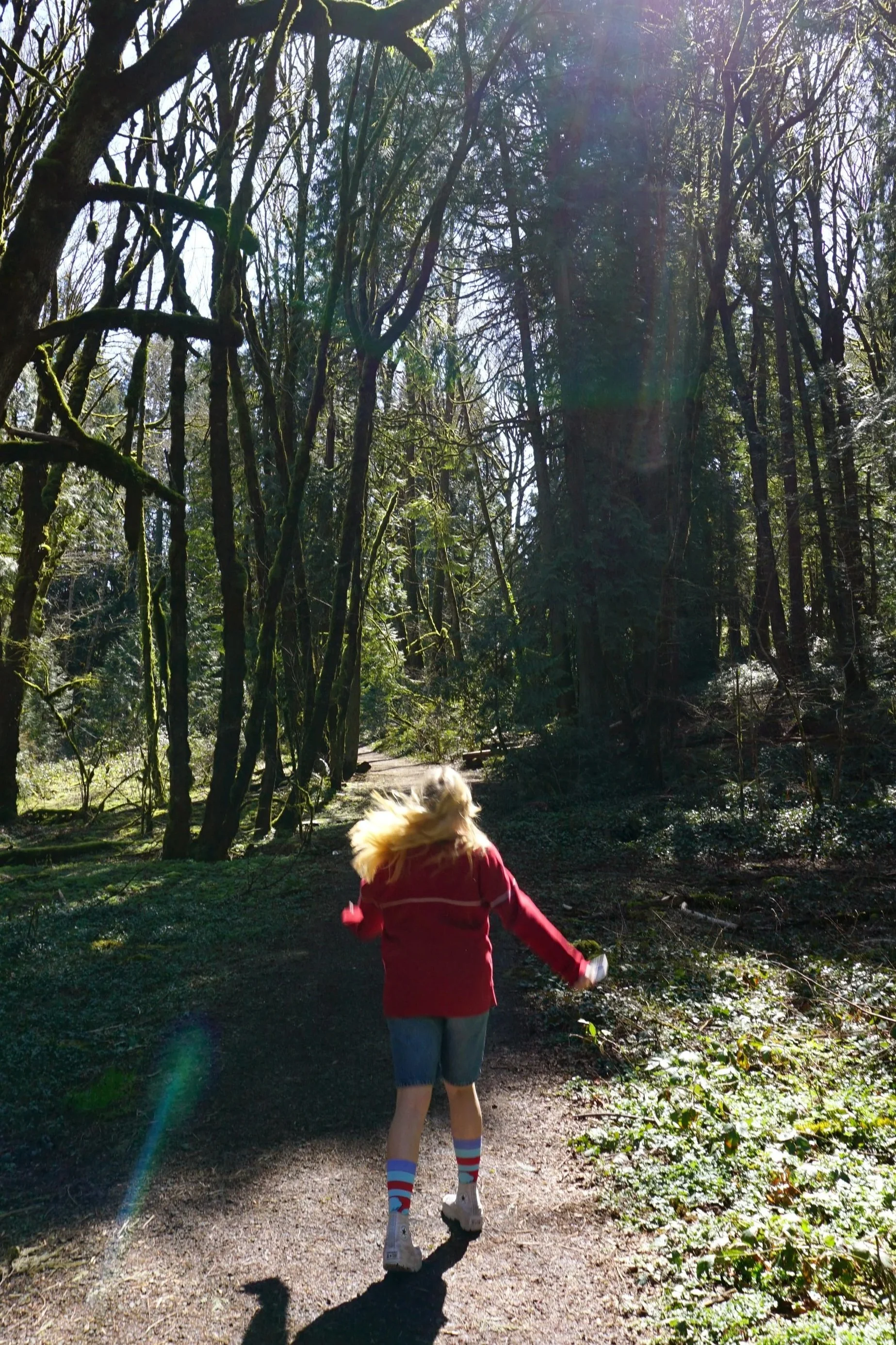 A woman skips through the forest while walking on a trail in Portland, Ore., on Tuesday, March 21, 2023. There was no one else on the trail, allowing the woman to skip freely on the path.