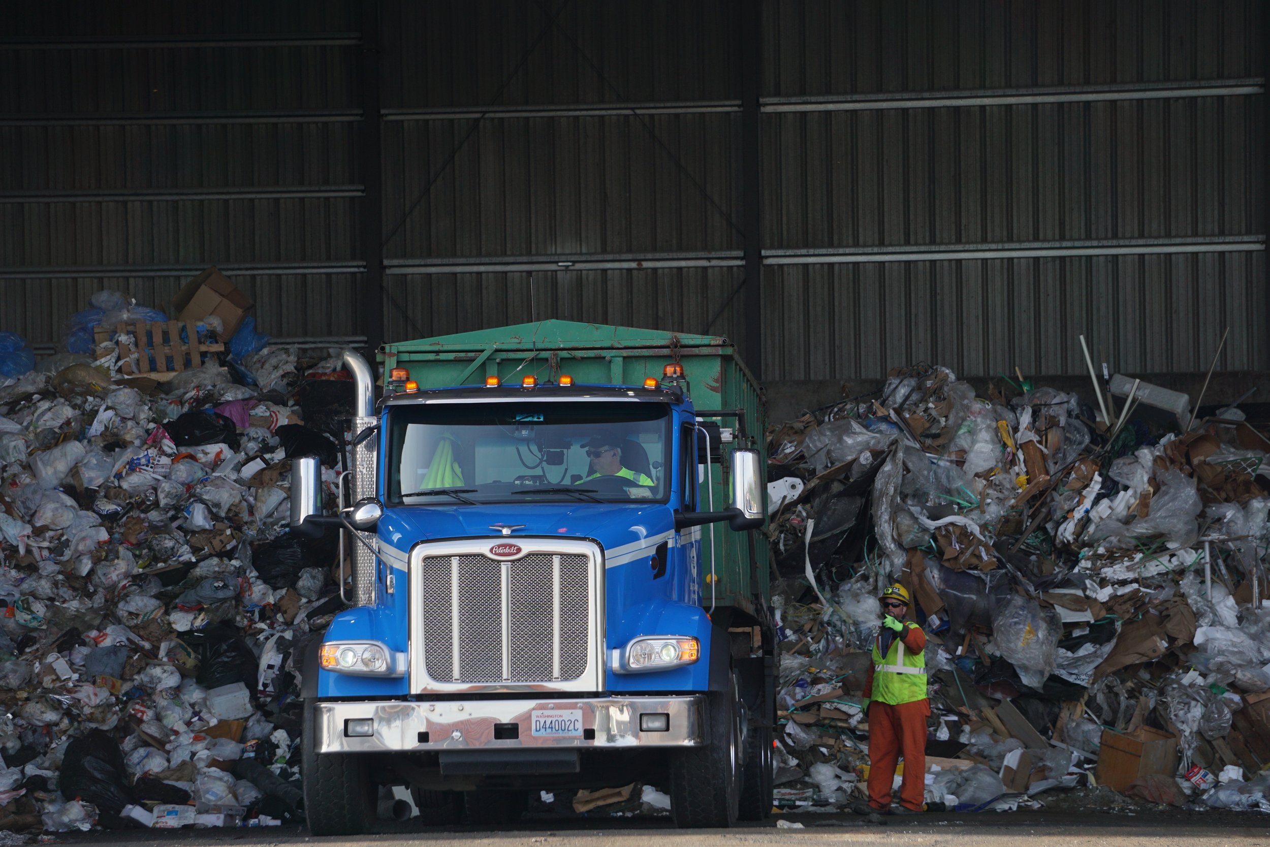  A dump truck unloads debris at the main garbage tipping floor at Recycling &amp; Disposal Services in Ferndale, Wash., on Feb. 6, 2026. Also known as end dumps, these 40-foot-long extended dump trucks fit material such as recycled waste and flood de