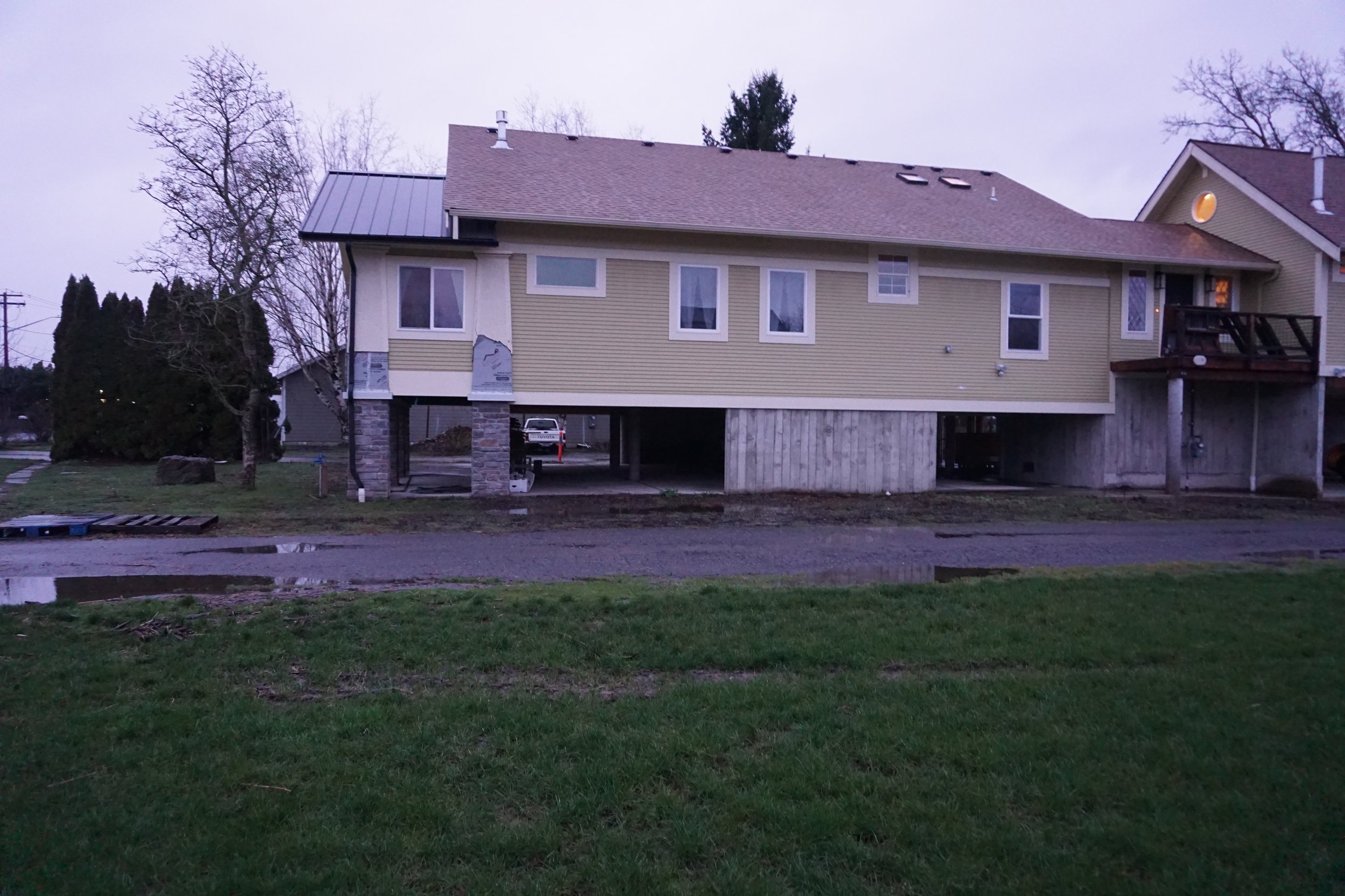  A Nooksack, Wash., home surrounded by floodwater on Dec. 11, 2025, and two months later on Feb. 2, 2026. After the 2021 floods, the homeowners elevated the house 8 feet and had about 2 feet to spare. In the second picture, the home did not receive a