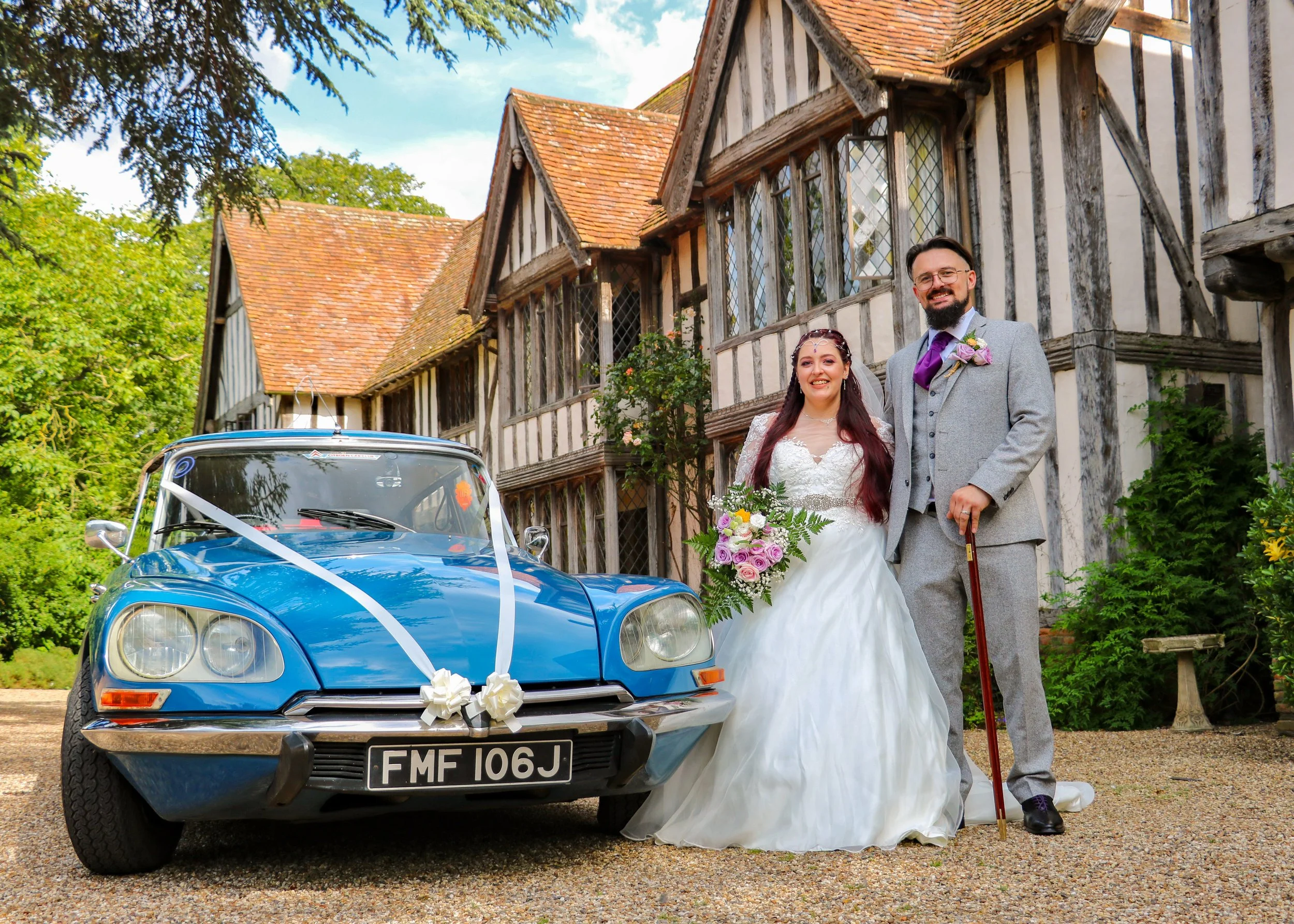 Bride and groom with a classic wedding car outside their North East wedding venue.
