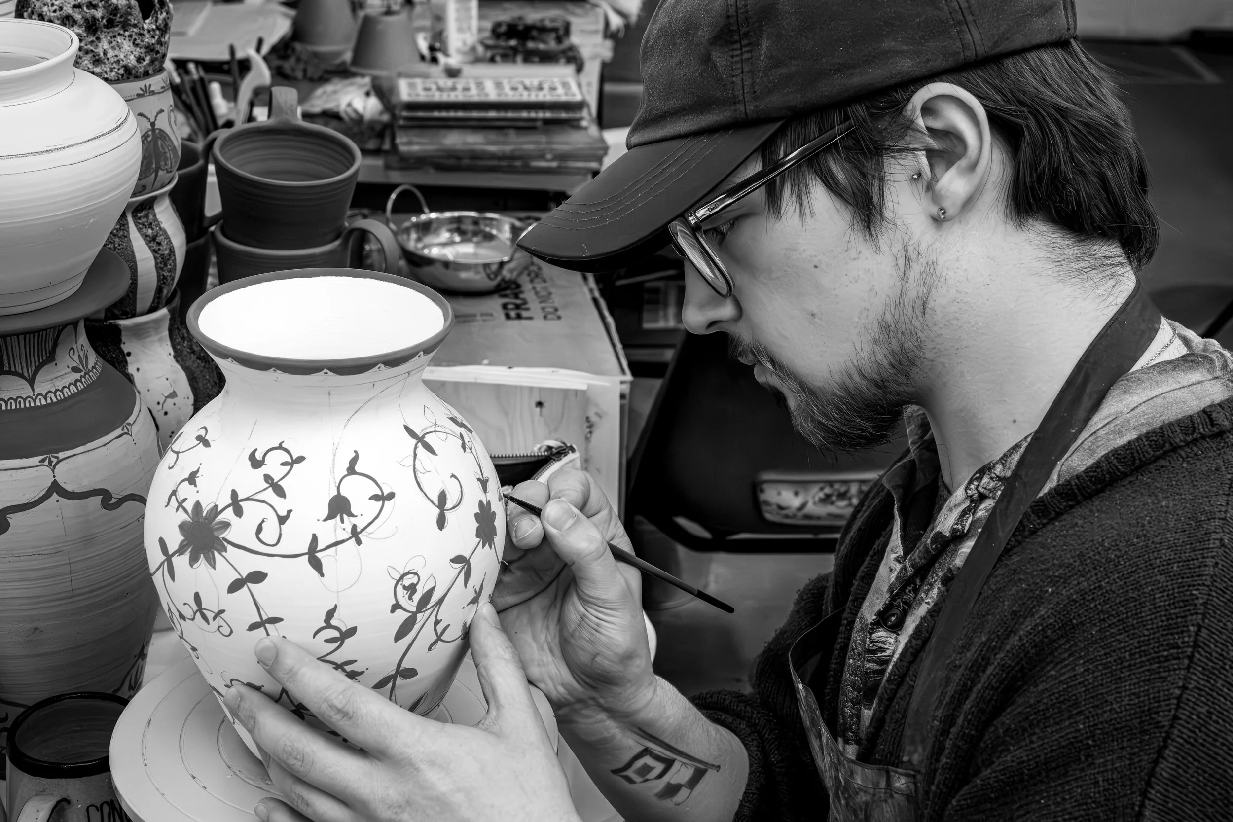 Matthew hand painting ceramic artwork, BA Student at the National Glass Centre.
