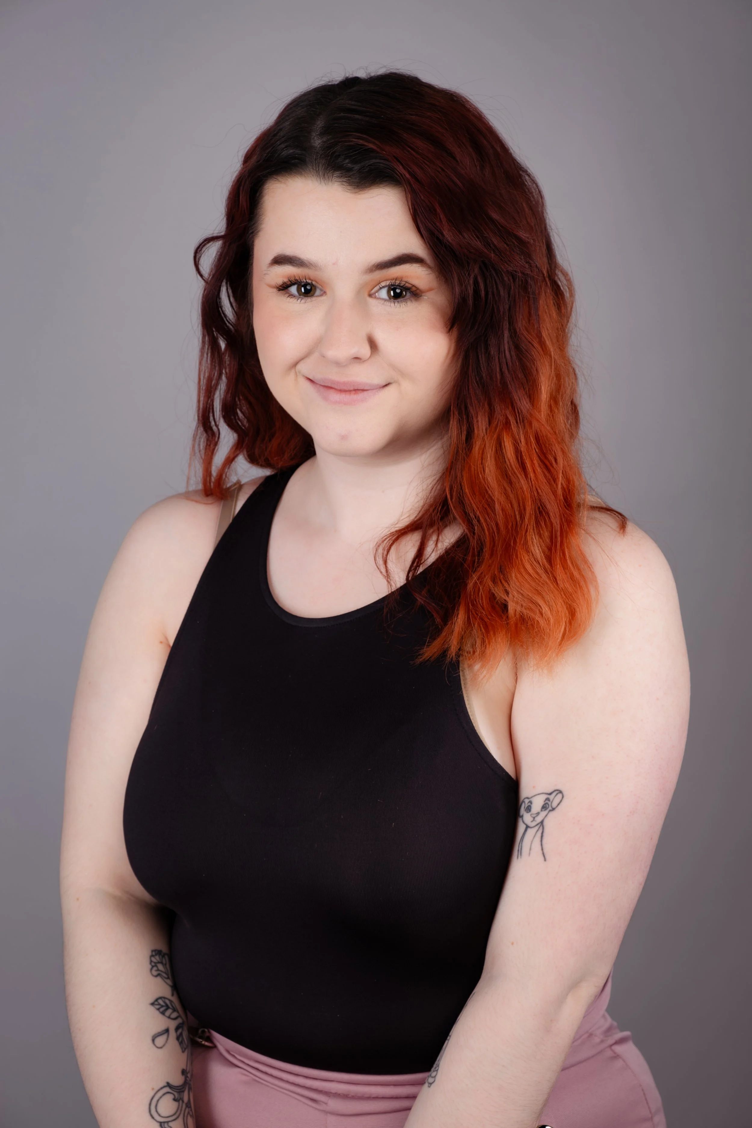 Studio headshot of a young woman photographed against a grey background.