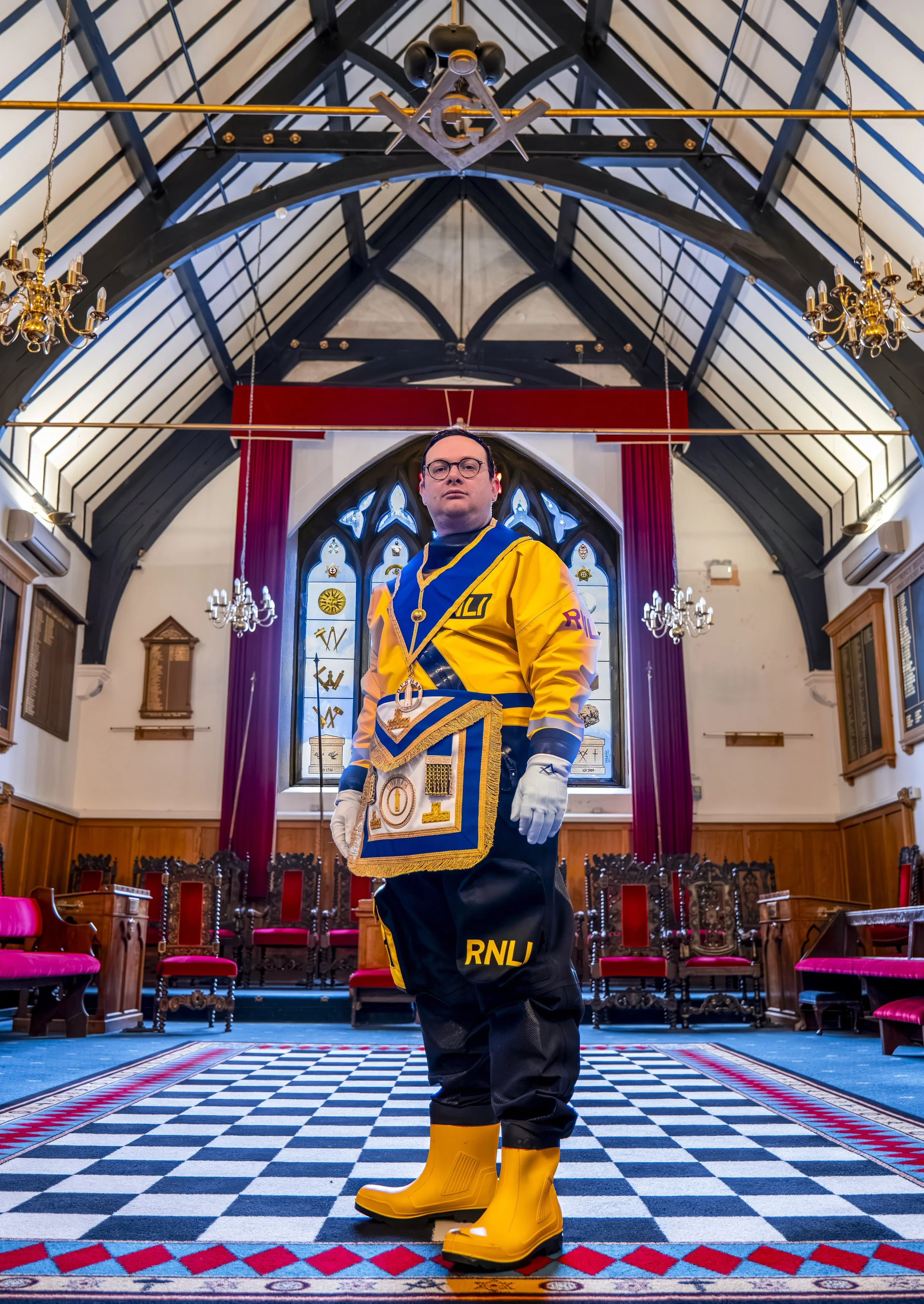 Environmental portrait of Man in RNLI drysuit and Freemason regalia in Durham Masonic Hall