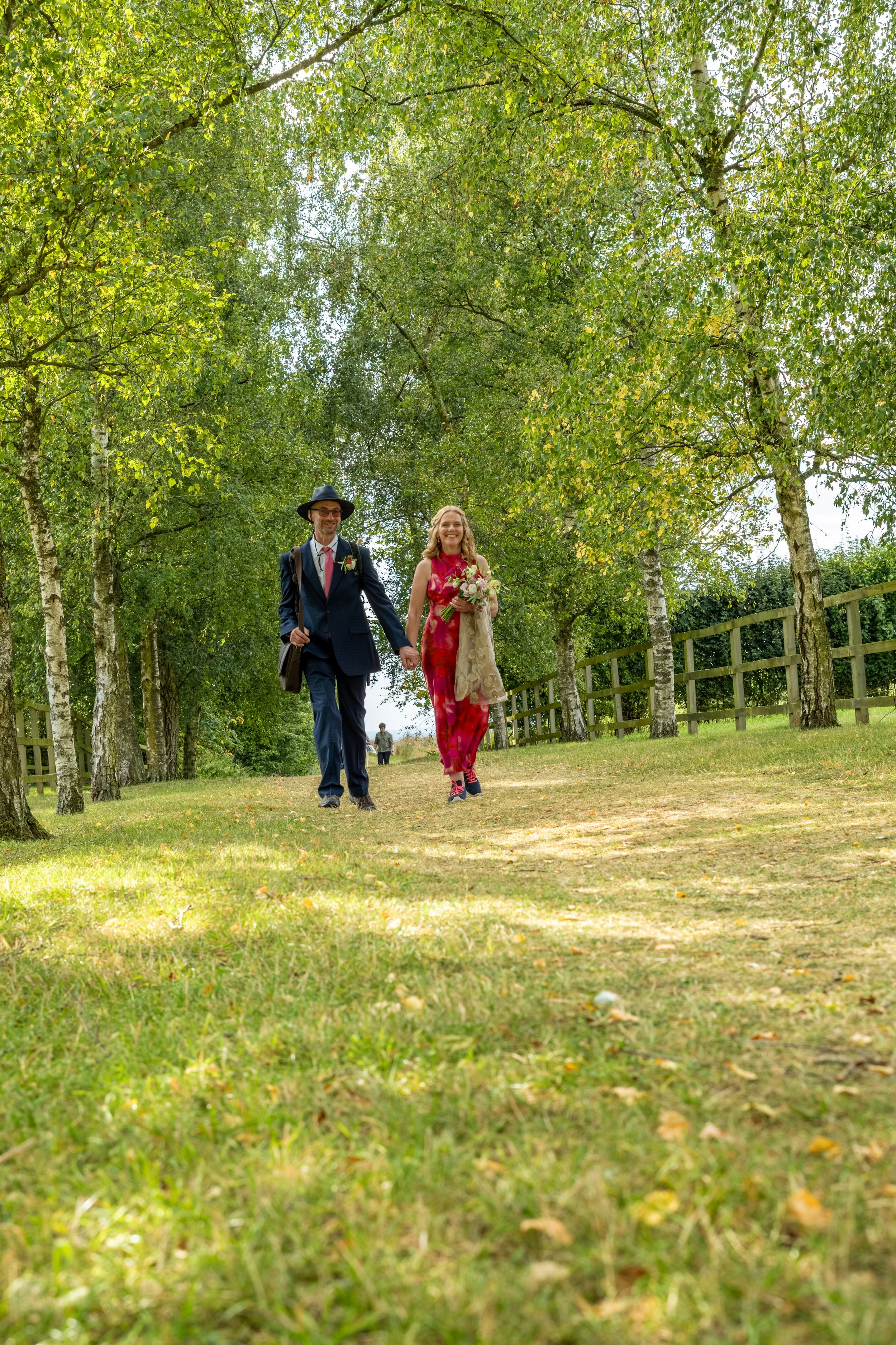 Wedding couple walking through the trees, candid wedding photography.