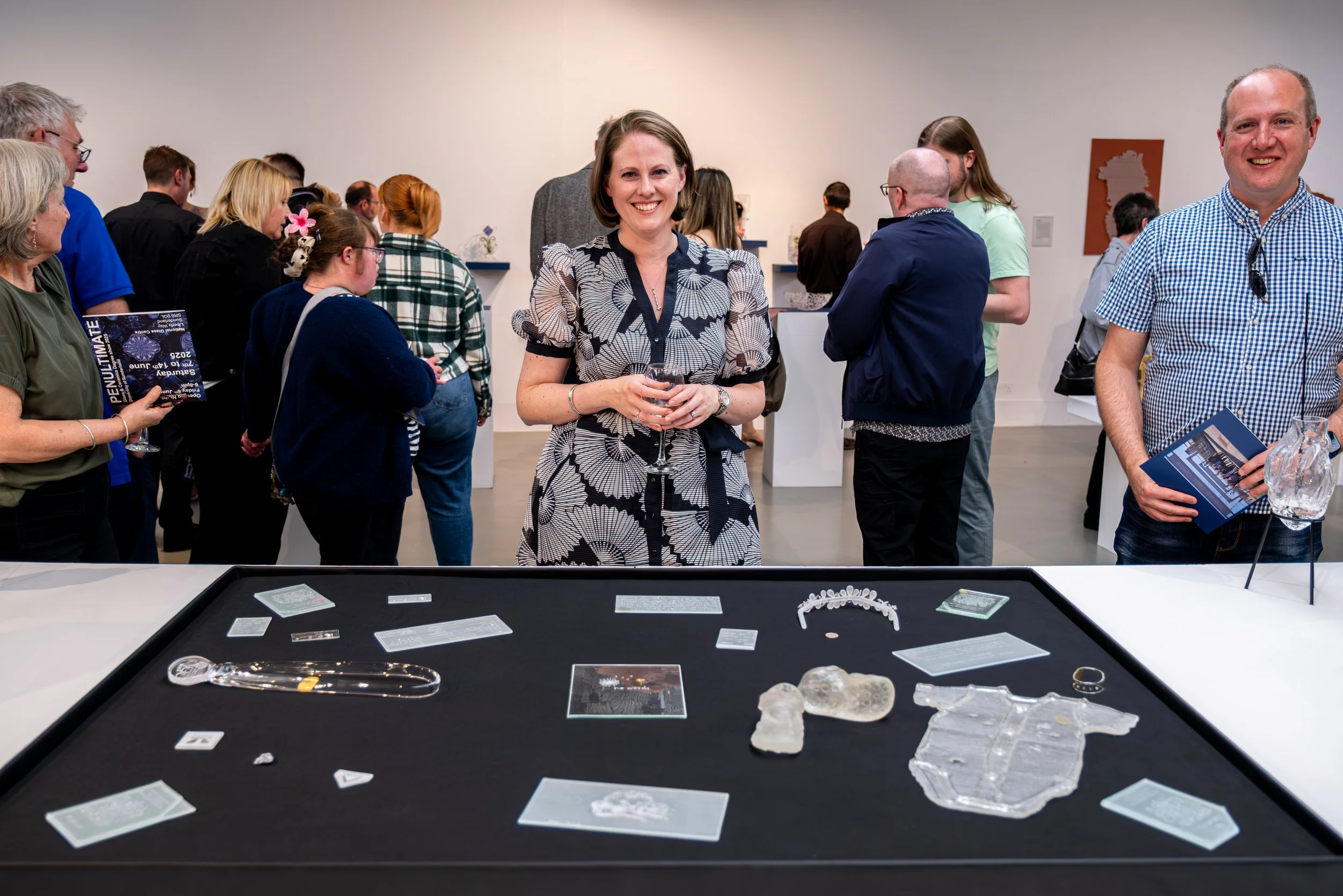 Artist photographed with glass artwork during an exhibition at the National Glass Centre.