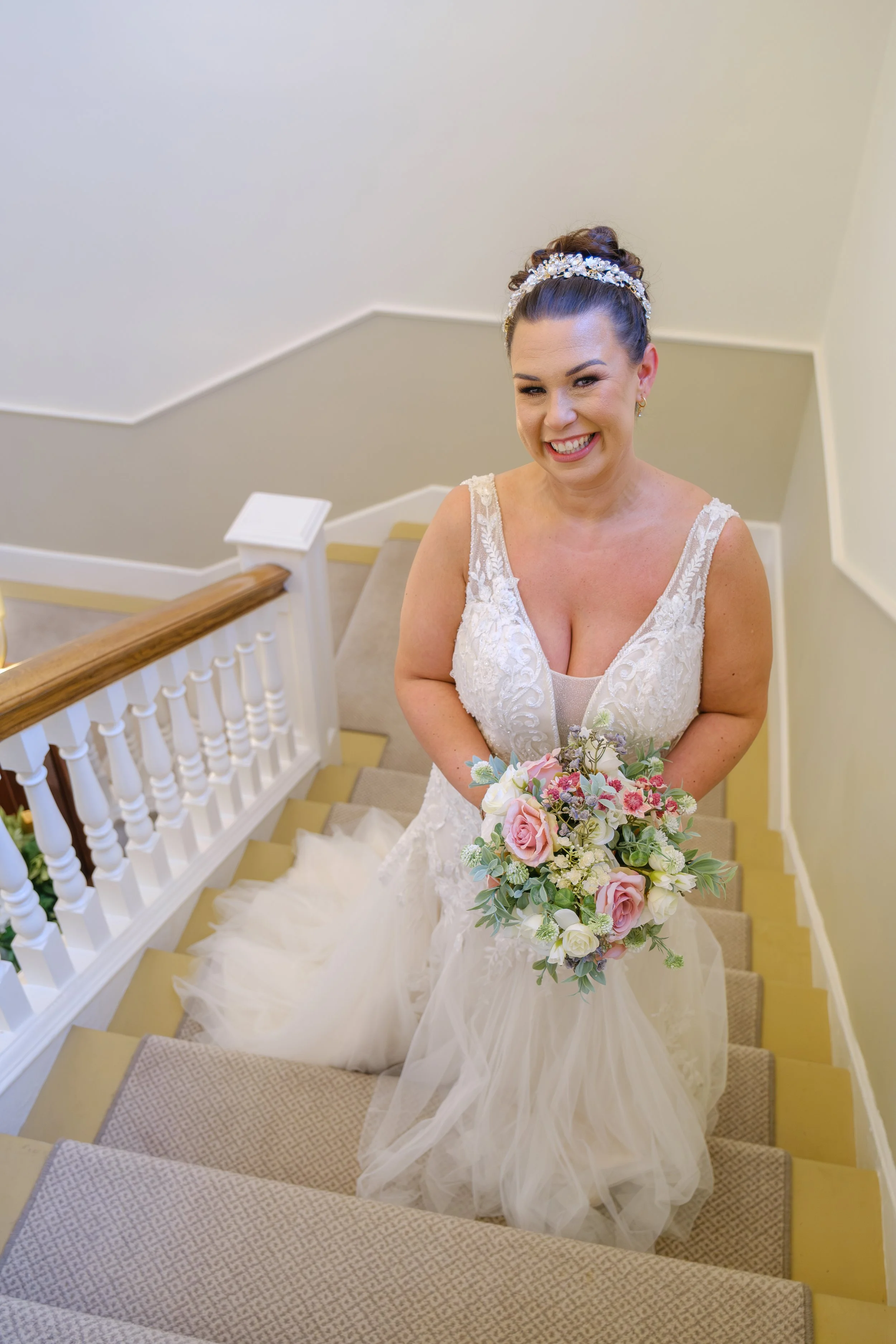 Bride standing on the staircase at The Story registry office in Durham on her wedding day.