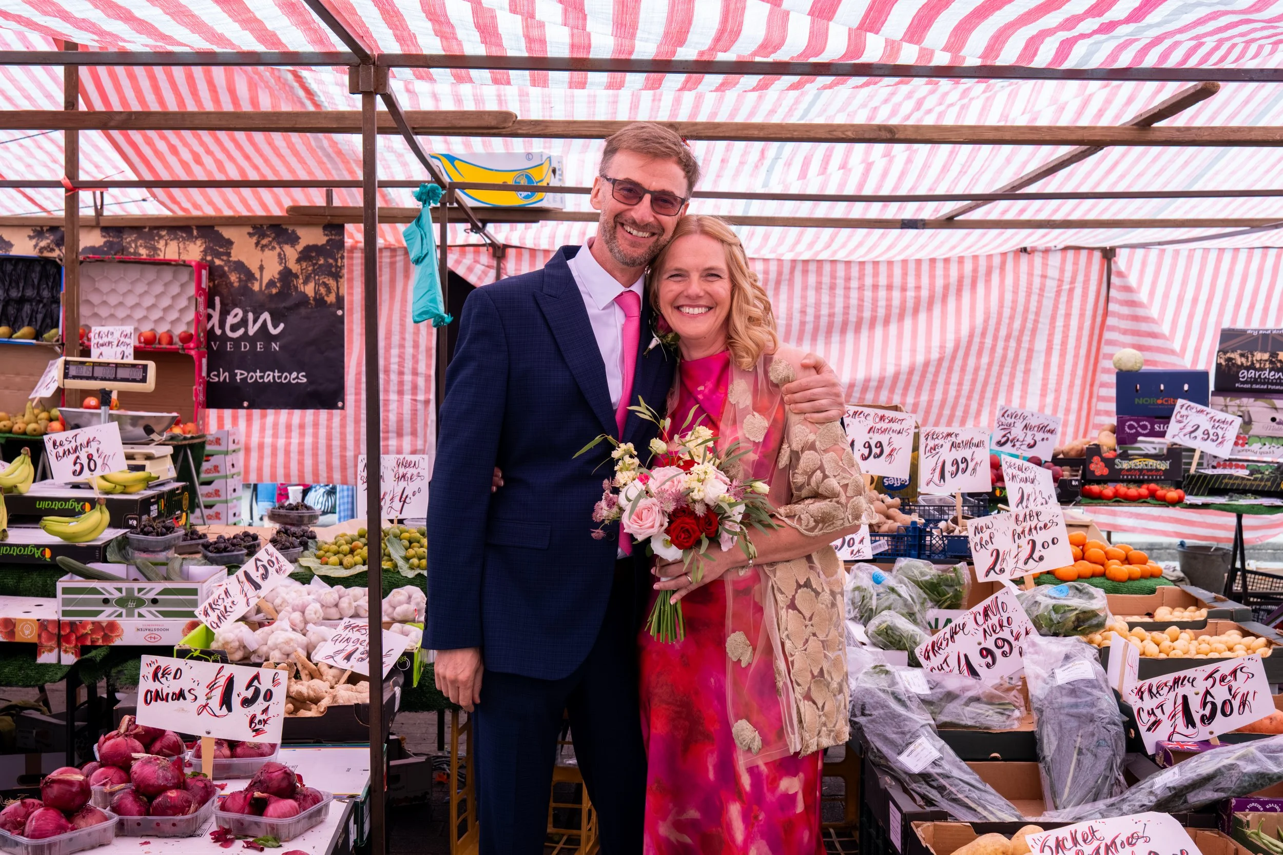 Bride and groom standing together in a historic market place during their North East wedding.