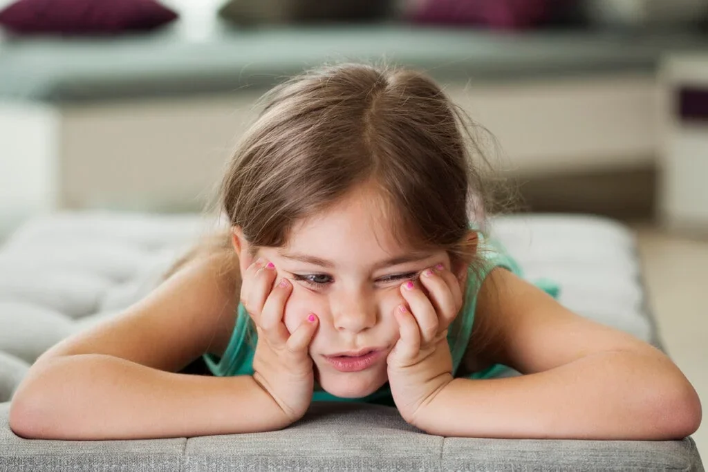 Little girl laying on furniture bored