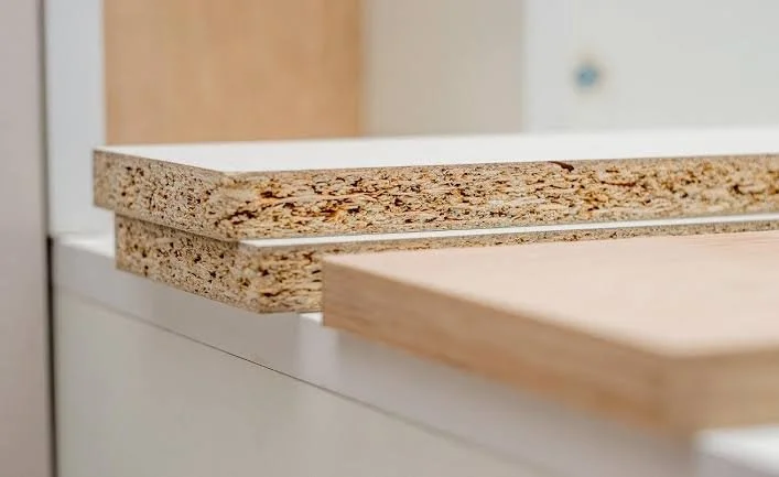 pieces of particle board compared to a real solid wood plank