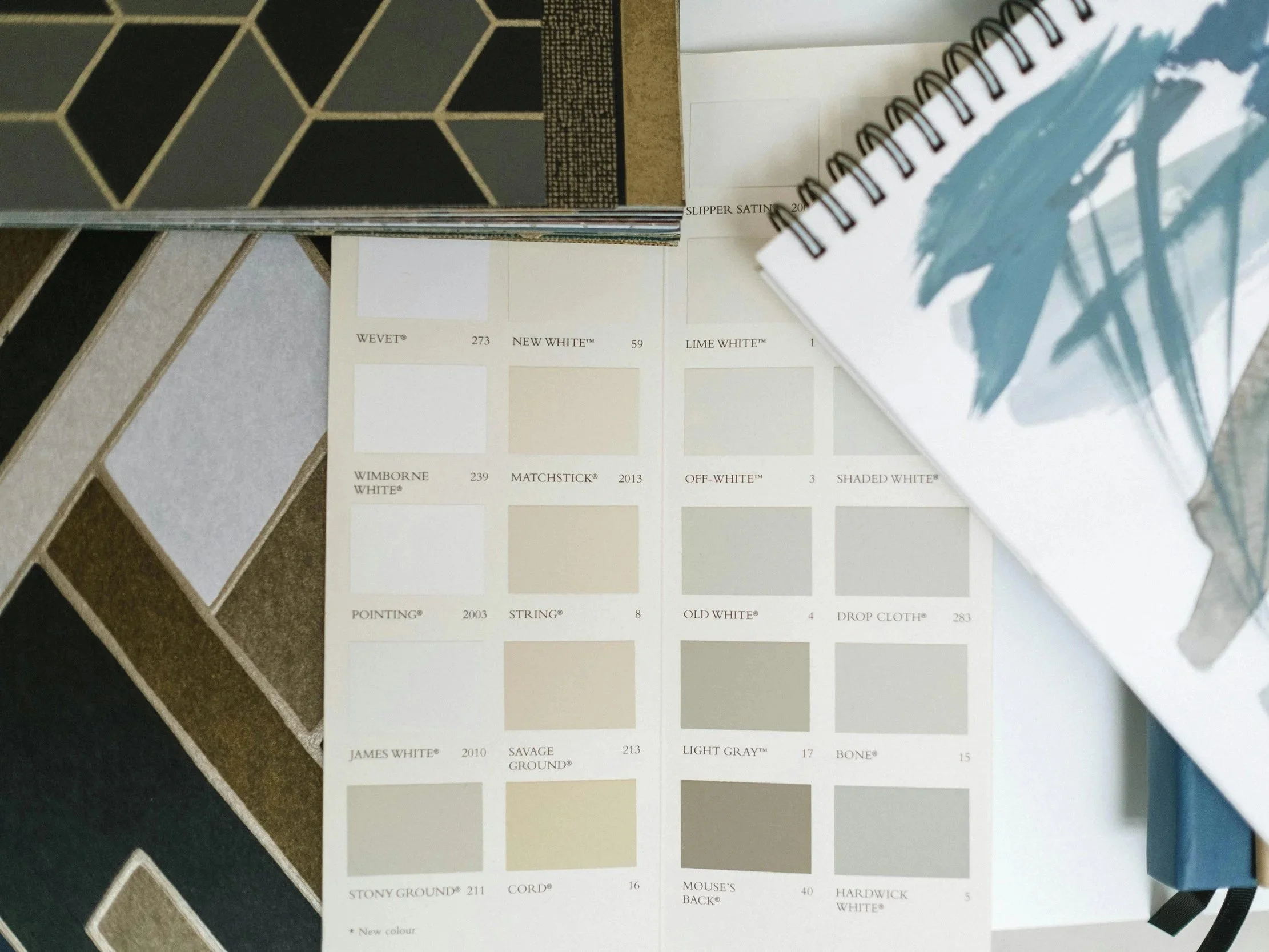 Color sample cards showing various shades of white, beige, gray, and black, with some geometric pattern samples visible on the left.