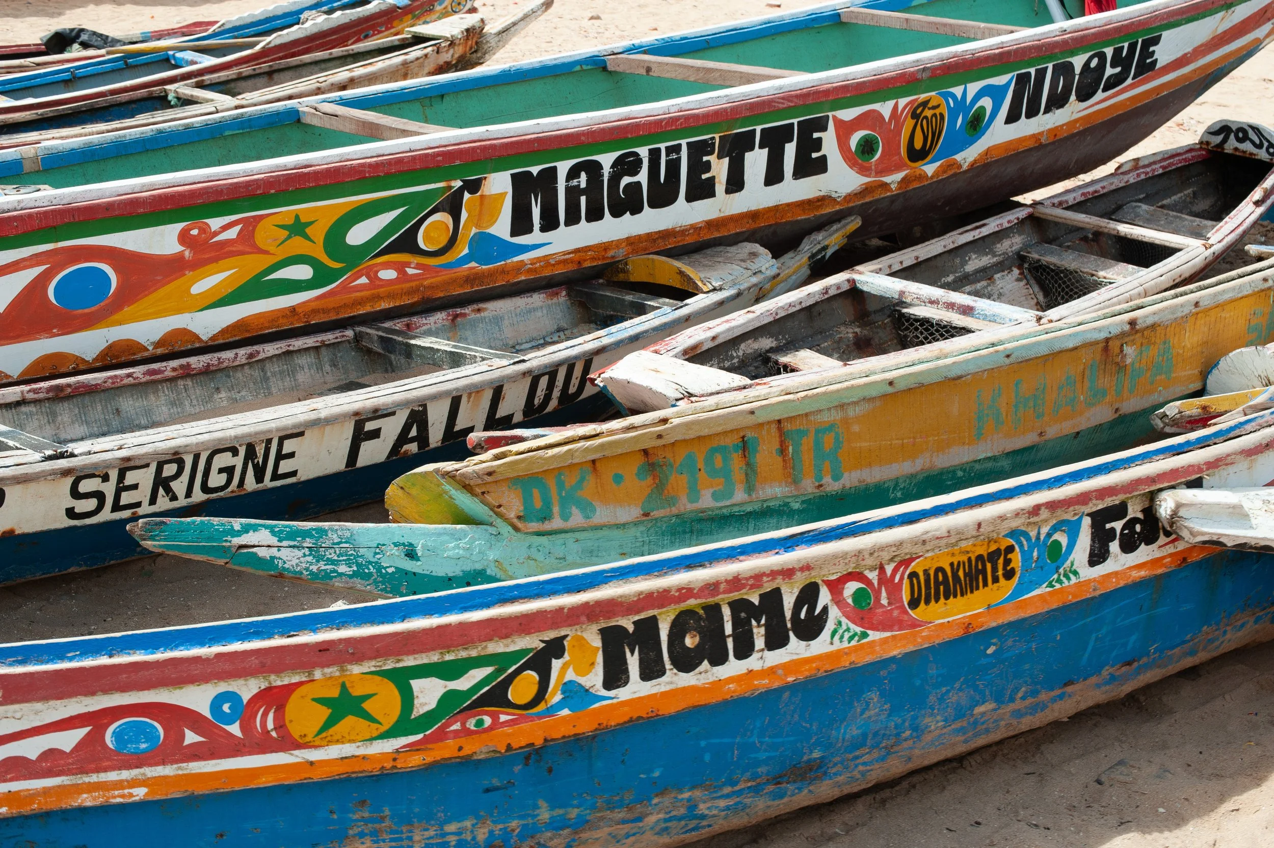 Colorful painted wooden boats on a sandy shore