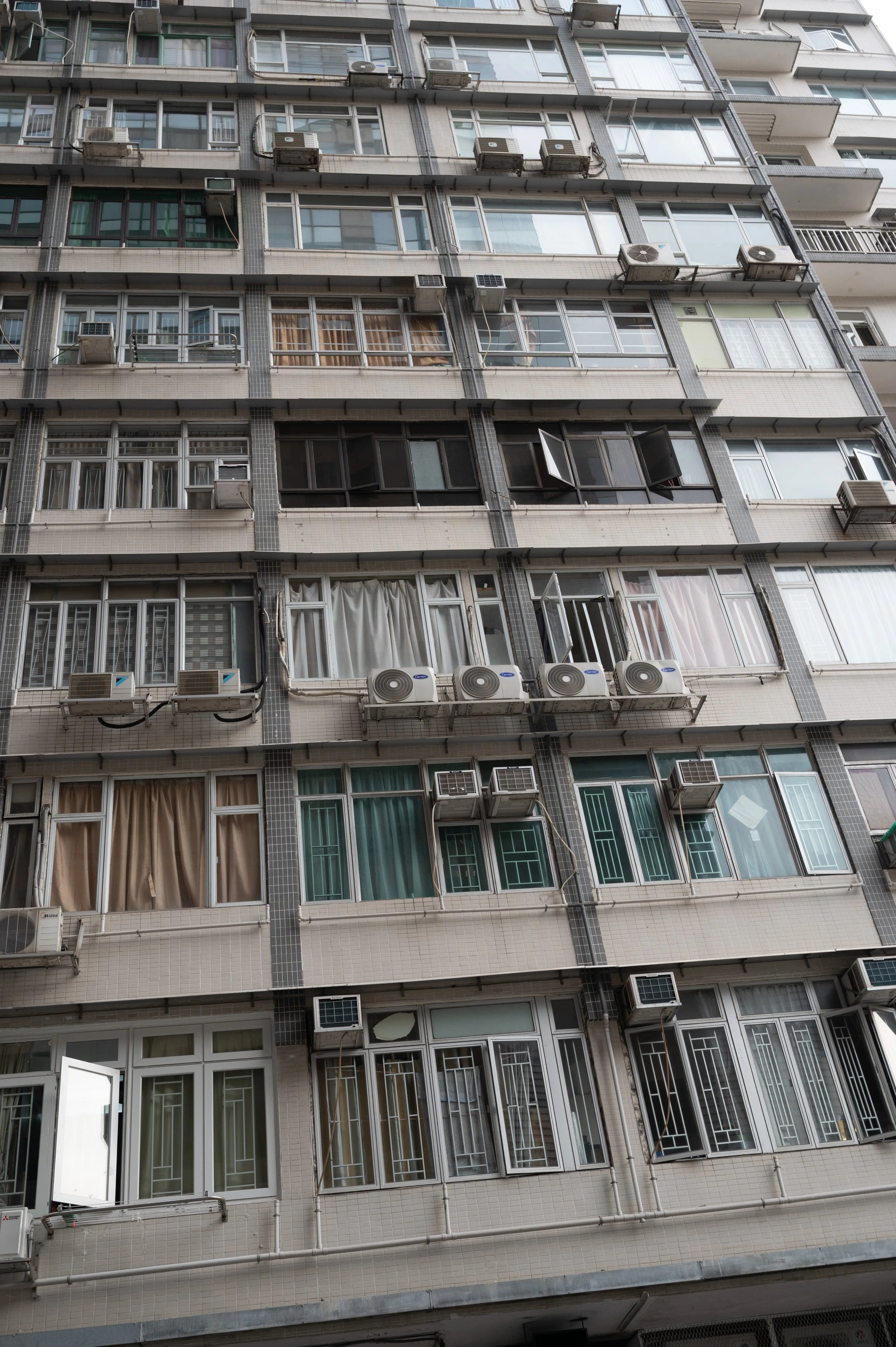 Exterior of a high-rise building with multiple windows and air conditioning units
