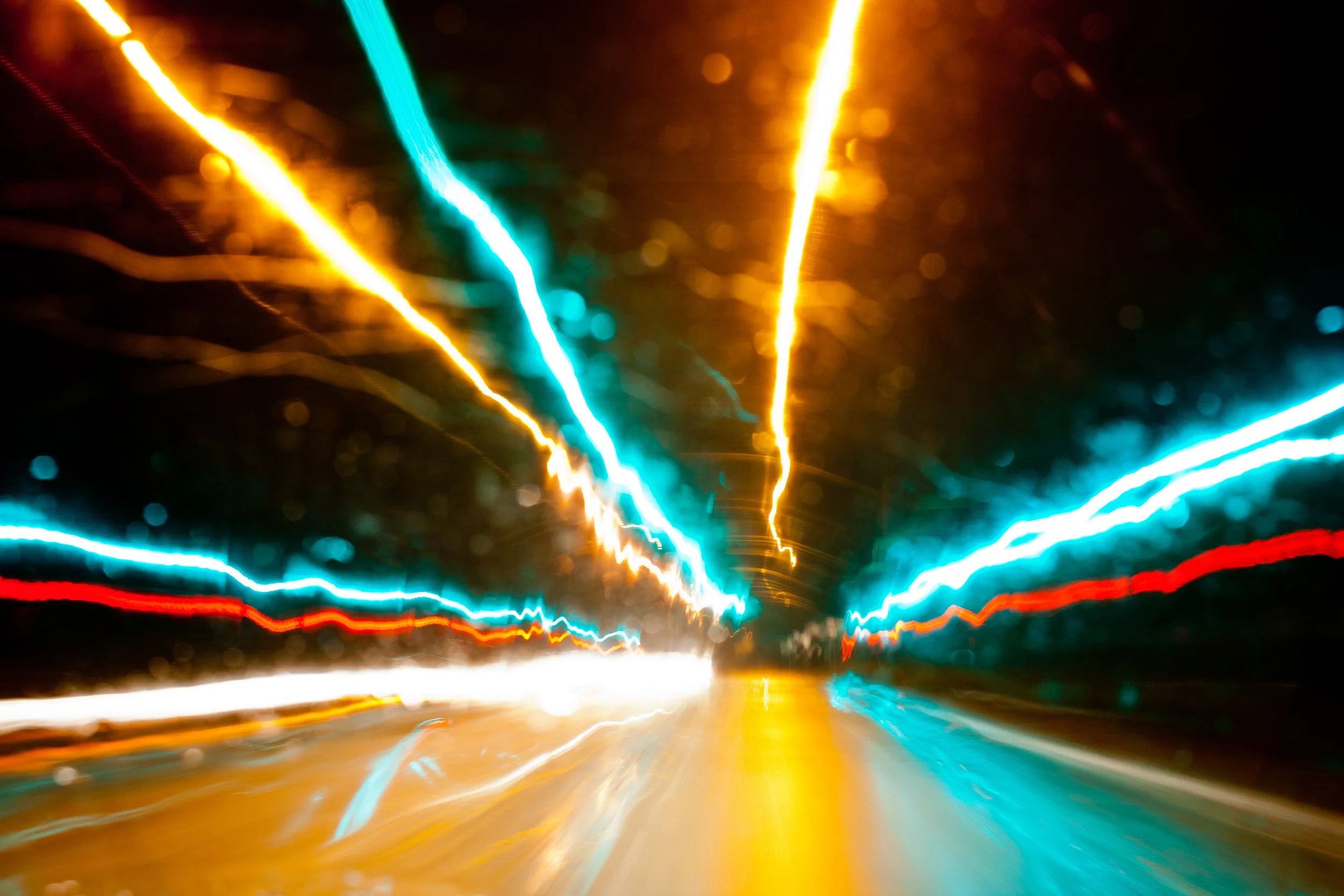 Colorful light trails creating a dynamic abstract pattern in a dark setting.