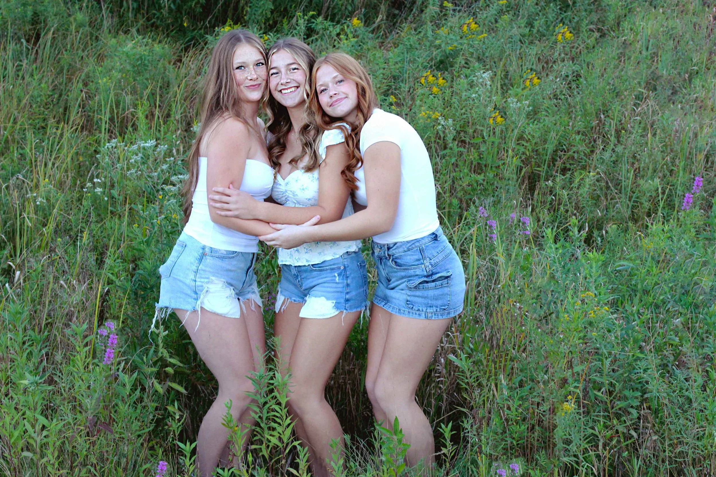 Three teen friends at an outdoor photo session in a field