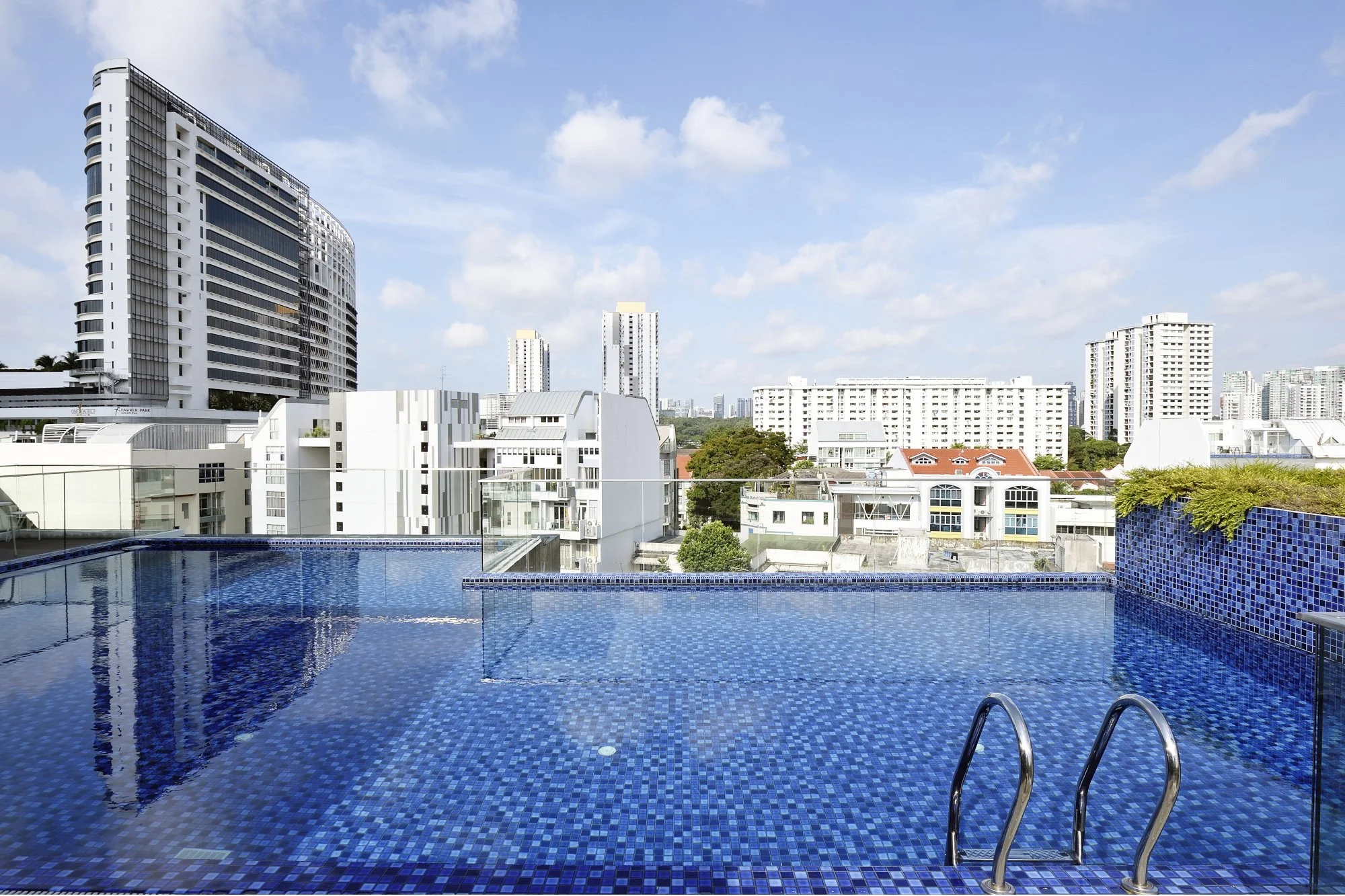 Outdoor views showcasing the architecture and pool design of a hospitality property in Singapore.