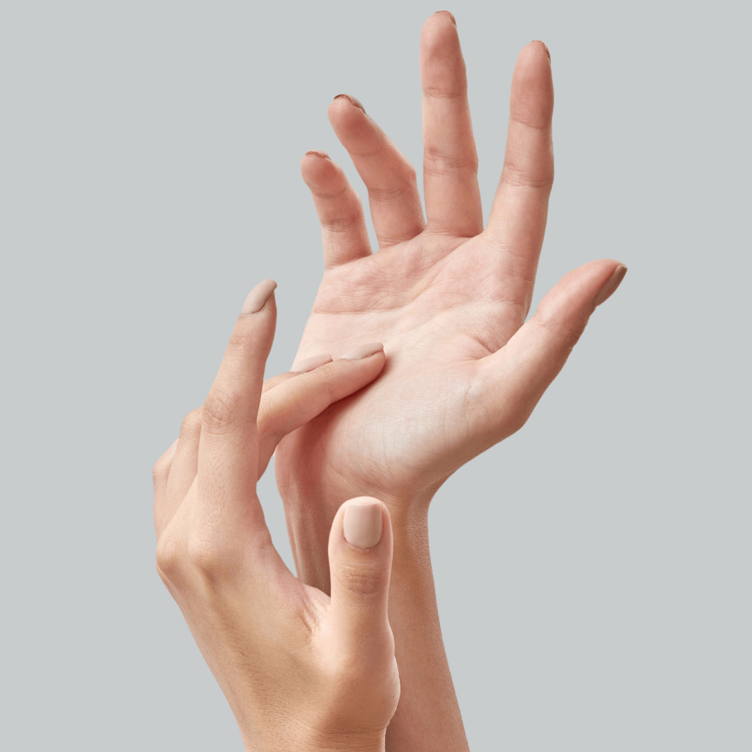 Close-up of a hand touching the wrist of another hand.