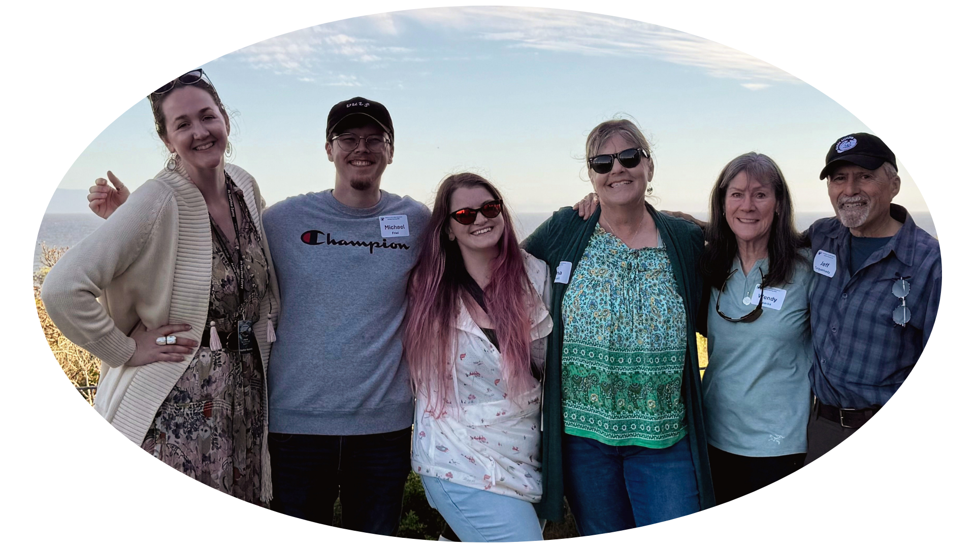 Alexis Galasso with the Sea Otter Savvy team and CAWS-certified photographers Jeff Torquemada and Wendy Sparks, standing together outdoors with the coast behind them at golden hour.