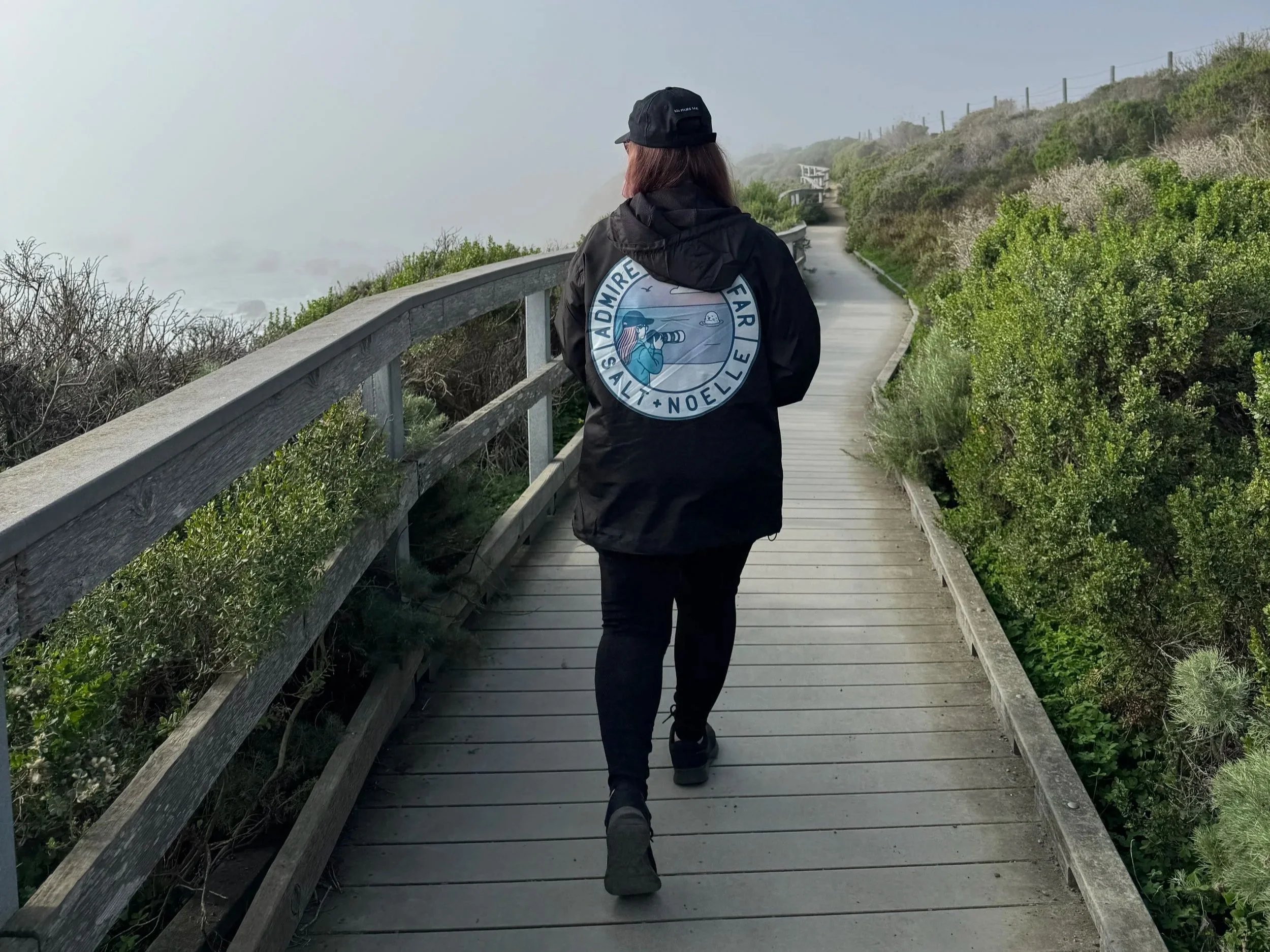 Alexis Noelle walks the boardwalk at the Piedras Blancas elephant seal rookery wearing a Salt + Noelle Admire from Afar jacket.