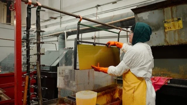 Worker in protective gear working with industrial equipment in a factory