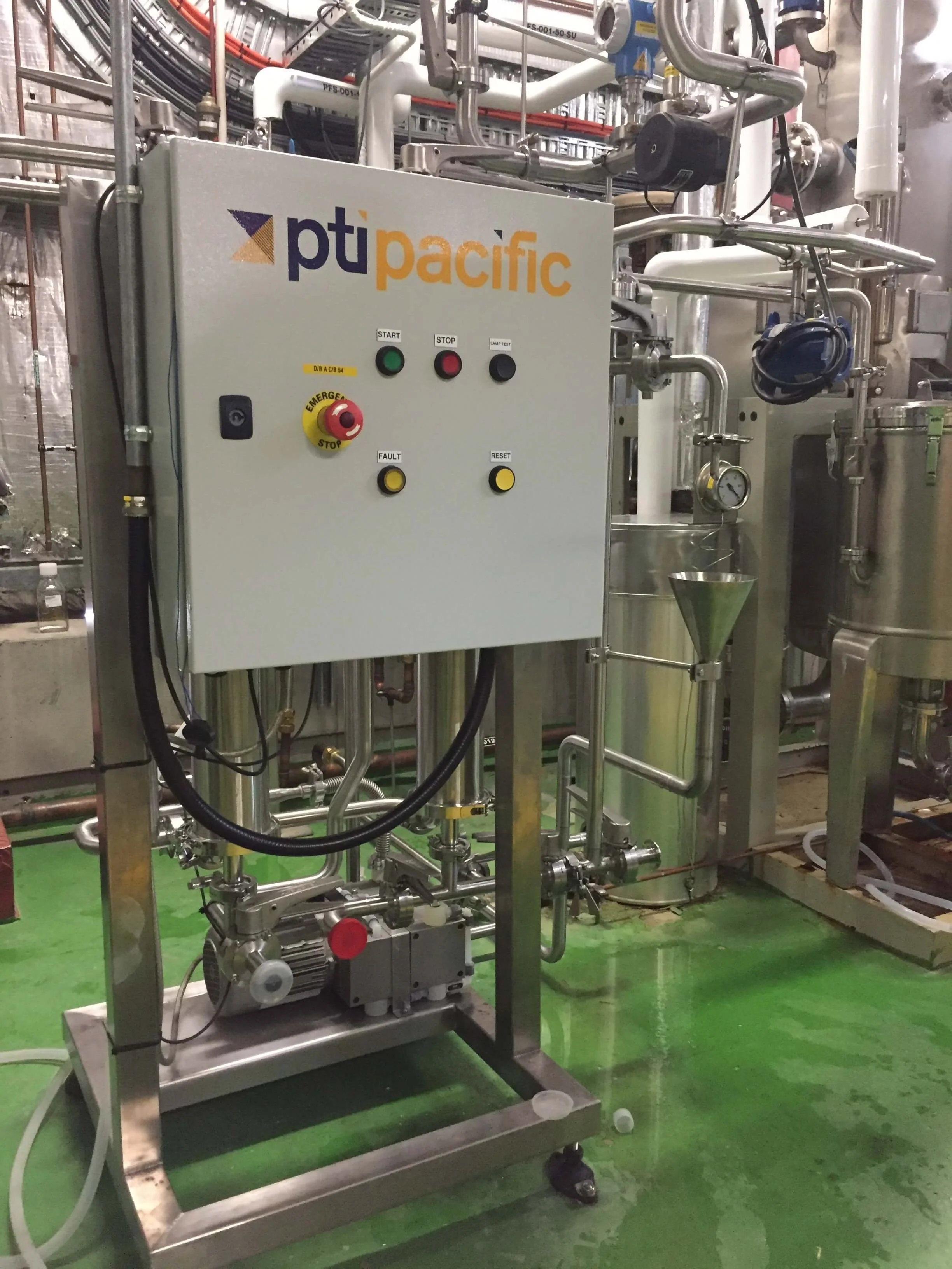 Industrial control panel with pipes and gauges in a processing plant.