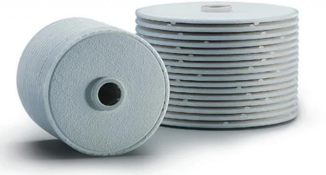 Stack of white water filter cartridges, with one cartridge lying on its side and the others stacked upright.