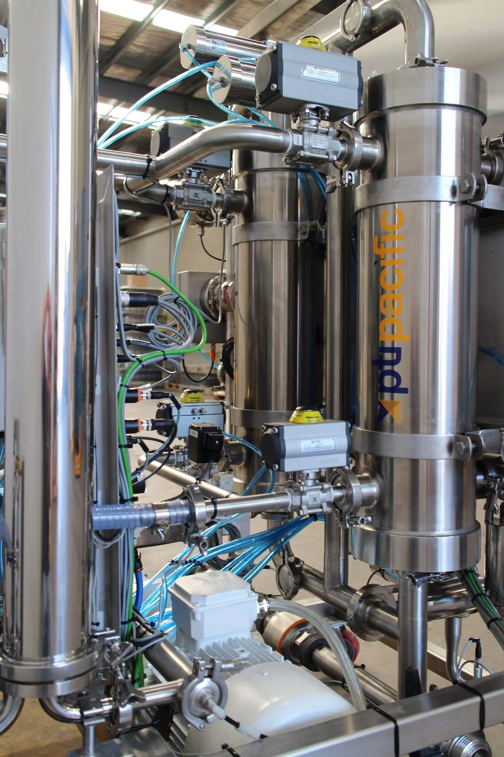 Industrial equipment with stainless steel tanks, pipes, and wires, labeled 'Pead Pacific'.