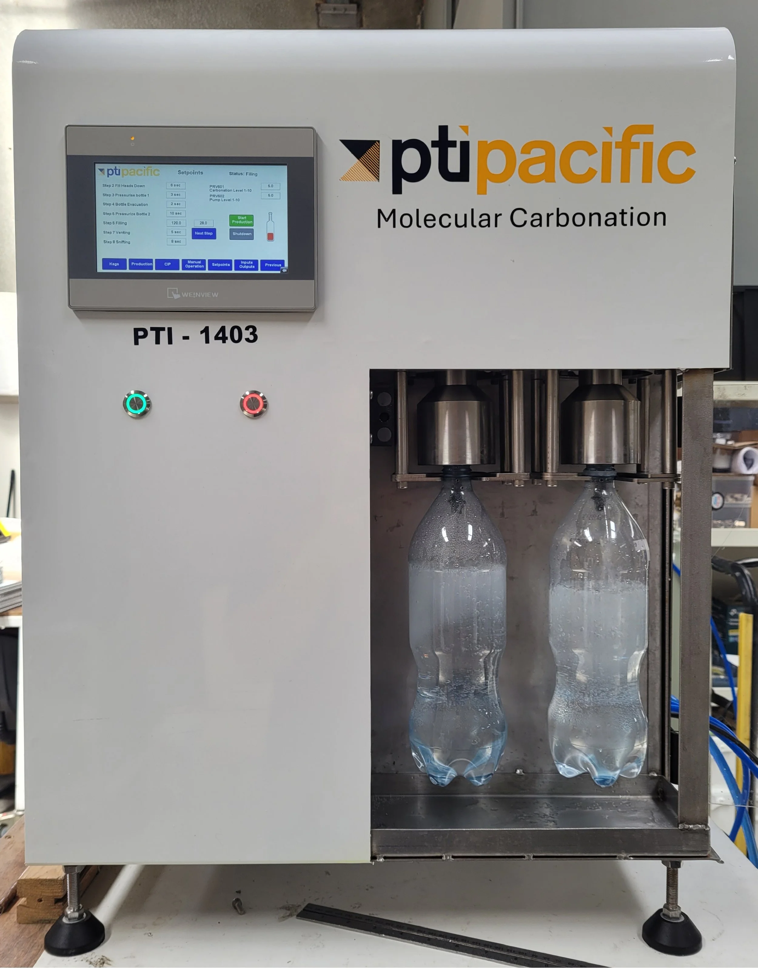 A machine labeled 'ptipacific Molecular Carbonation' with two plastic water bottles being filled with carbonated water. The machine has a touchscreen display and two indicator lights, one green and one red.