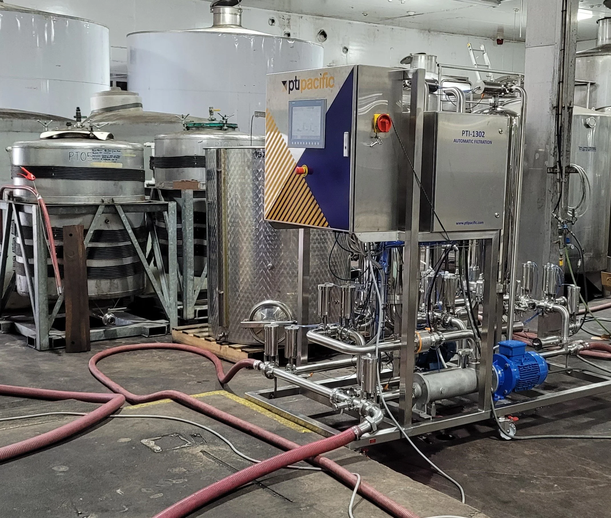 Industrial water filtration machine in a factory setting with tanks and pipes.