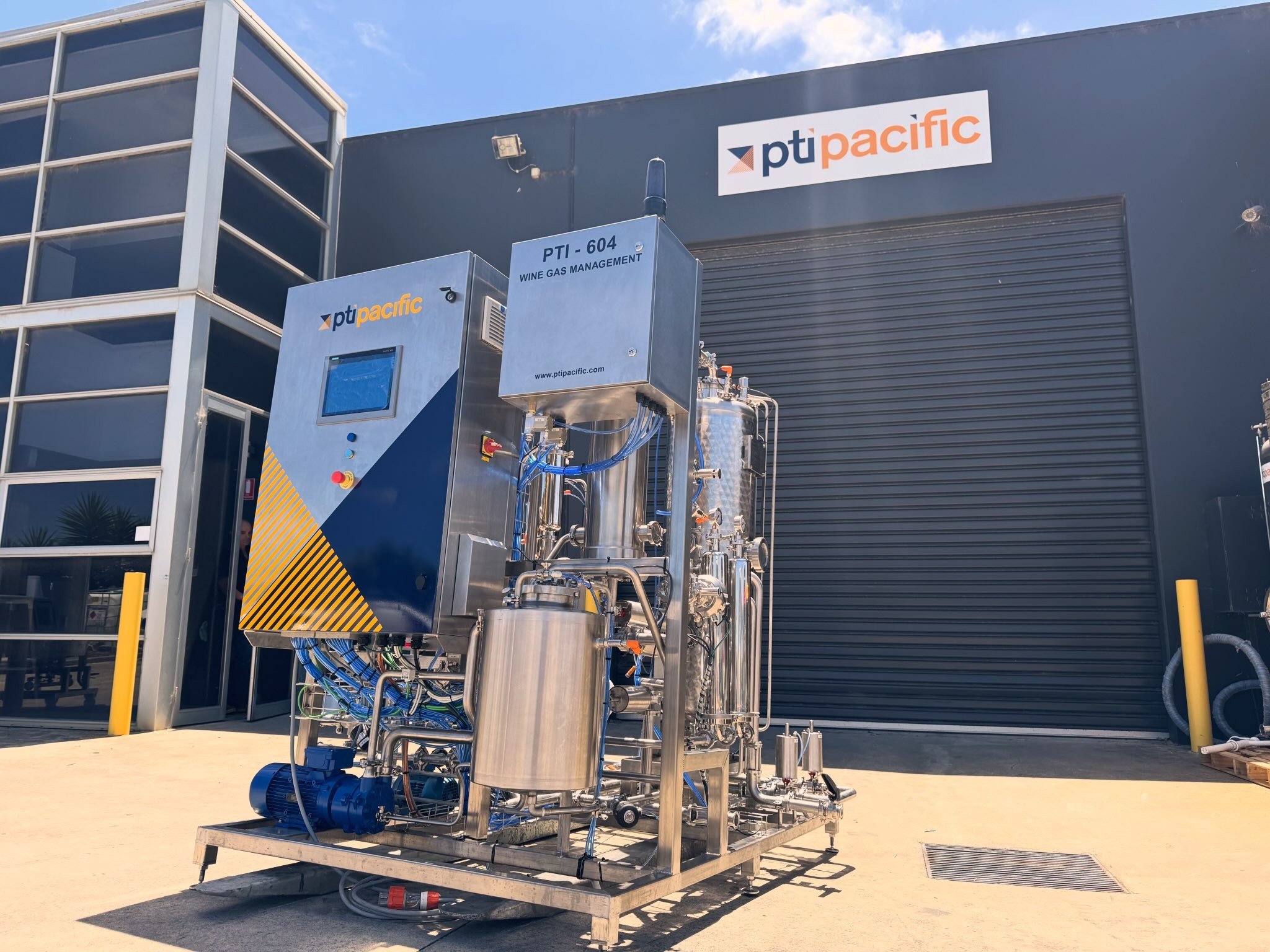 Industrial equipment for wine gas management outside a building with PT Pacific signage.