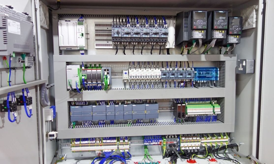 Electrical control panel with various switches, relays, circuit breakers, and wiring.