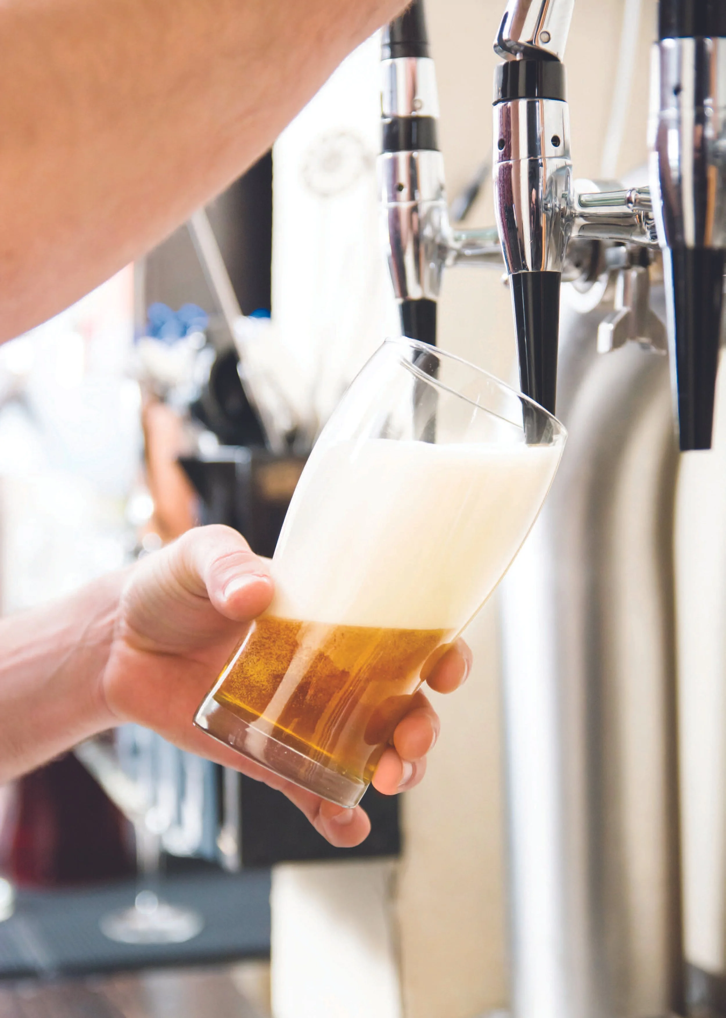Person pouring beer from a tap into a glass