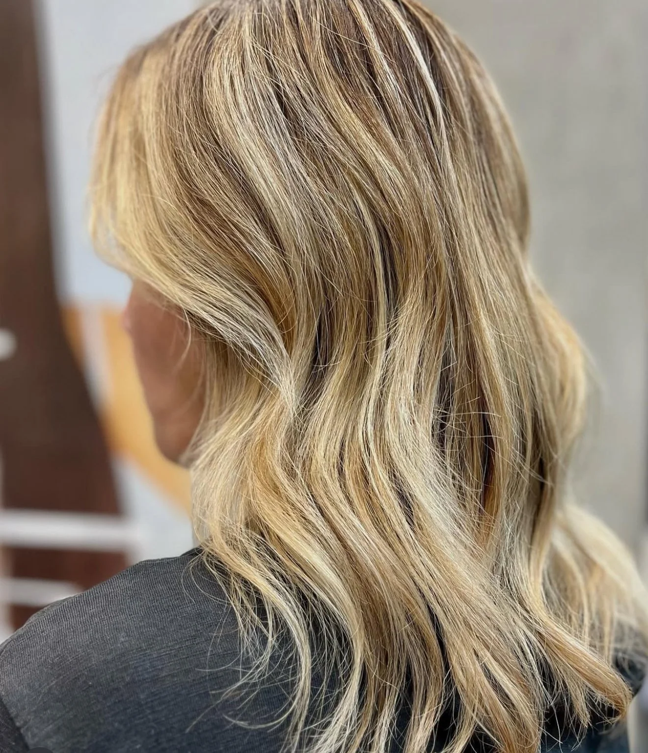 Blonde wavy hair, shoulder-length, styled in loose waves.