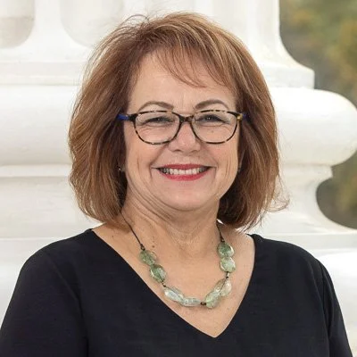 Endorsement of Maria Elena Durazo. She is wearing a black top and a light green necklace in front of a white column.