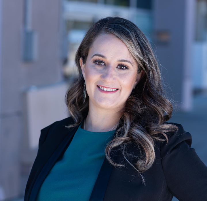 Endorsement of Imelda Padilla for Eunisses Hernandez. Portrait of councilmember Padilla wearing a black blazer and a teal top standing against a blurred background of a building.