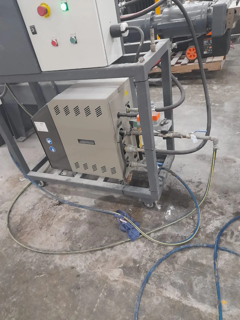 Equipo industrial con cables y tuberías conectado en un entorno de fábrica.