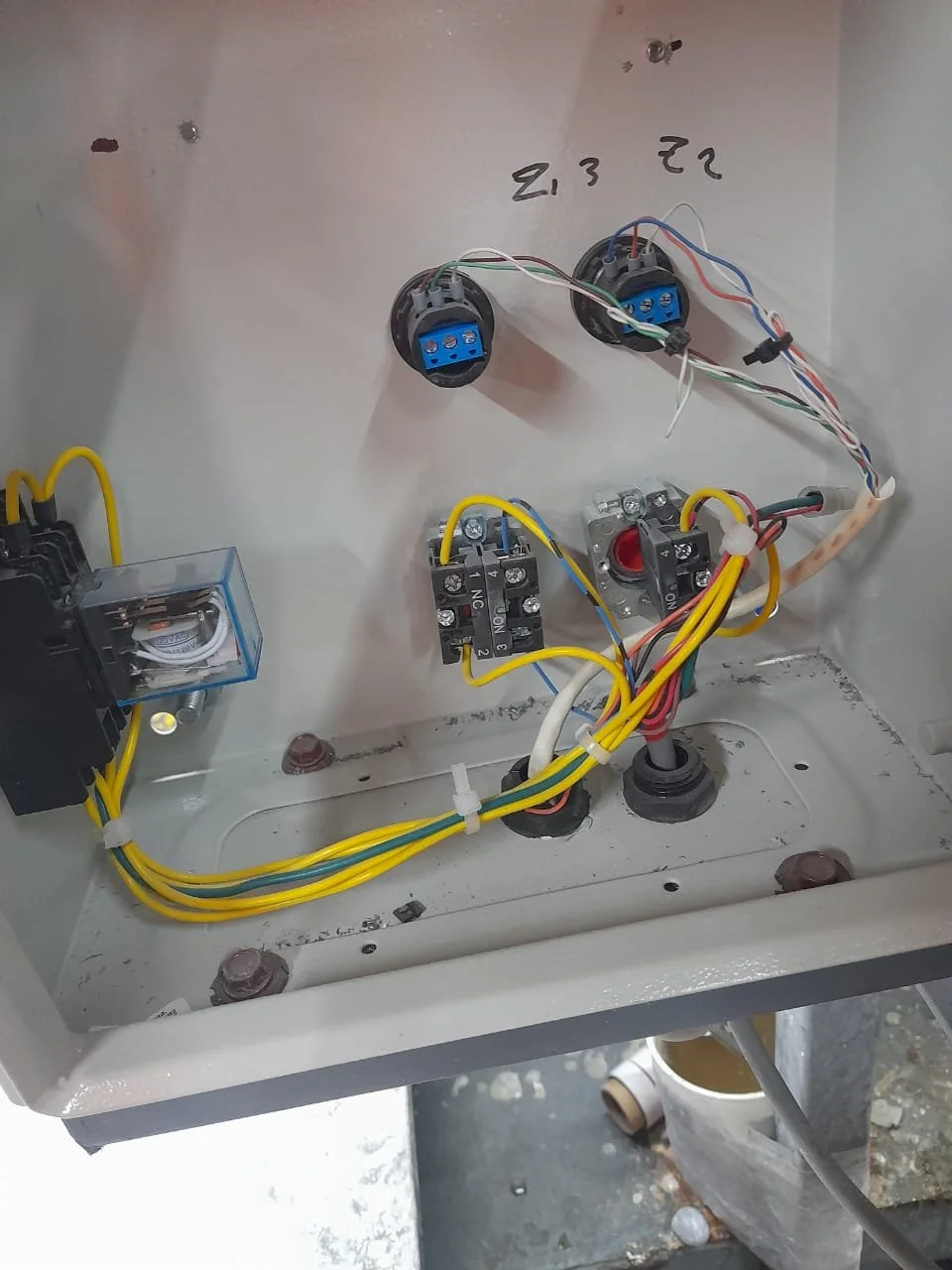 Interior de una caja eléctrica con componentes, cables y conexiones eléctricas.