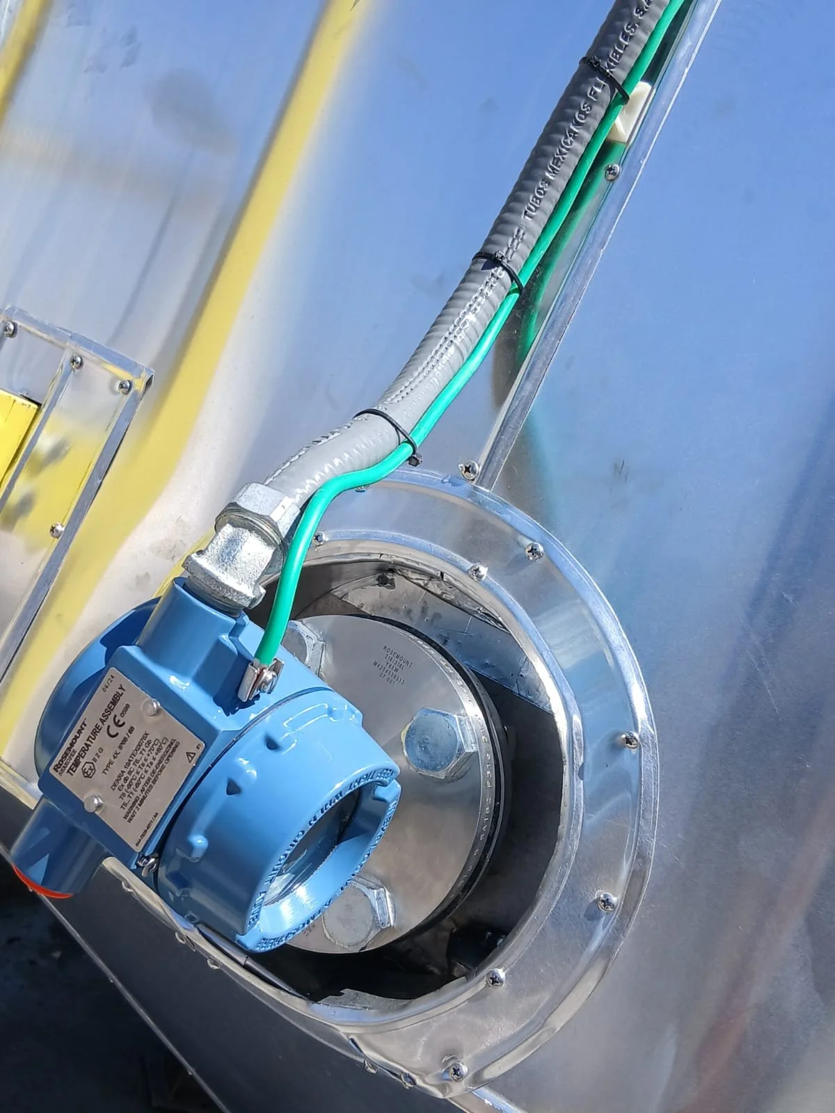 Componentes mecánicos y cables de un sistema de ventilación o maquinaria industrial en una estructura metálica.