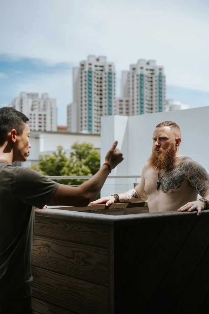 A certified instructor guiding a user through a cold plunge session outdoors, teaching proper breathing techniques and safety protocols.