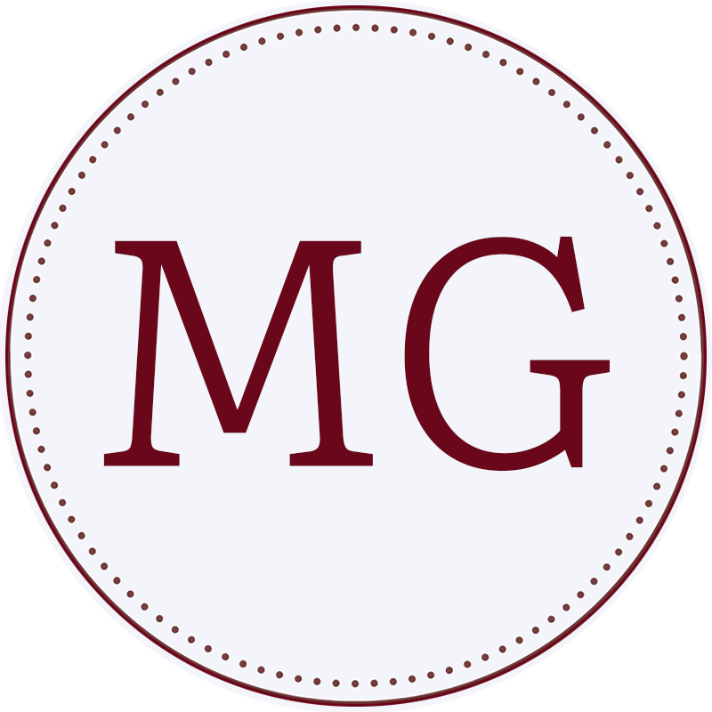 Material Girl Guesthouse logo mark—circular monogram badge with MG initials.